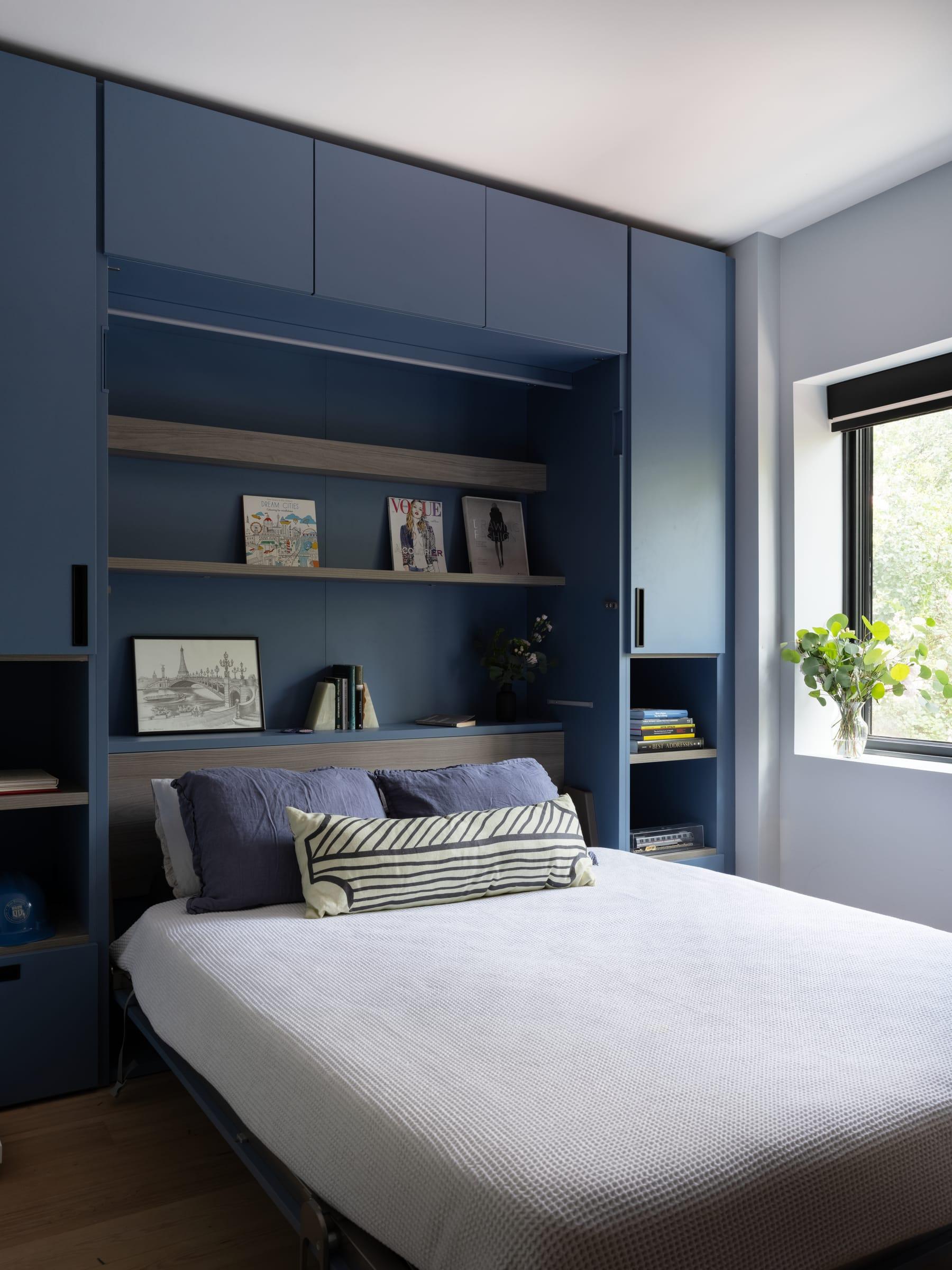 Blue bed wall with shelves around the bed