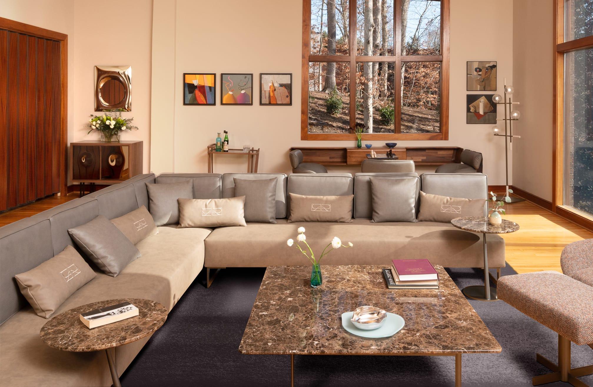 Grey sofa around a marble coffee table by tall windows