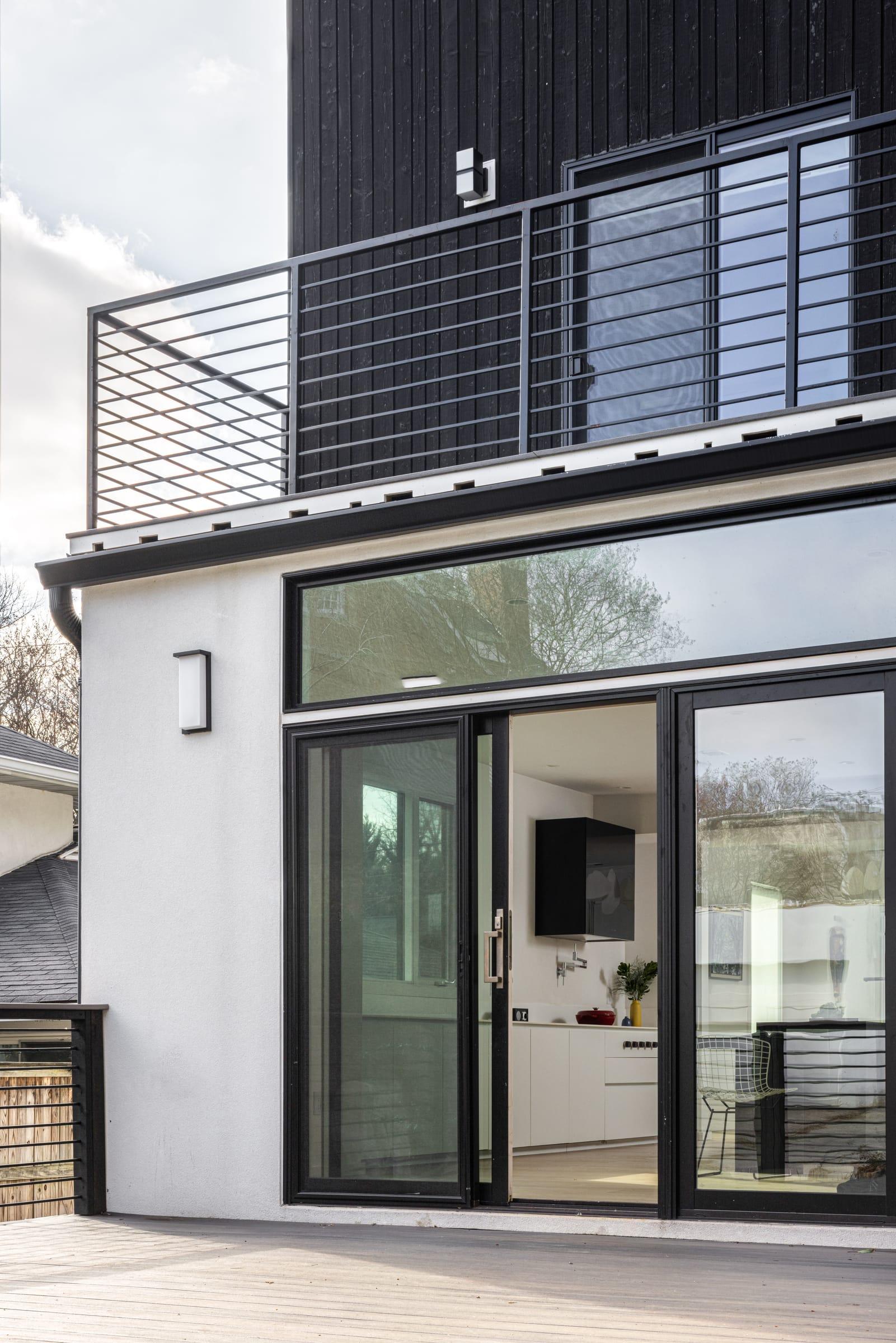 Rear of the house with a balcony over the glazed kitchen doors