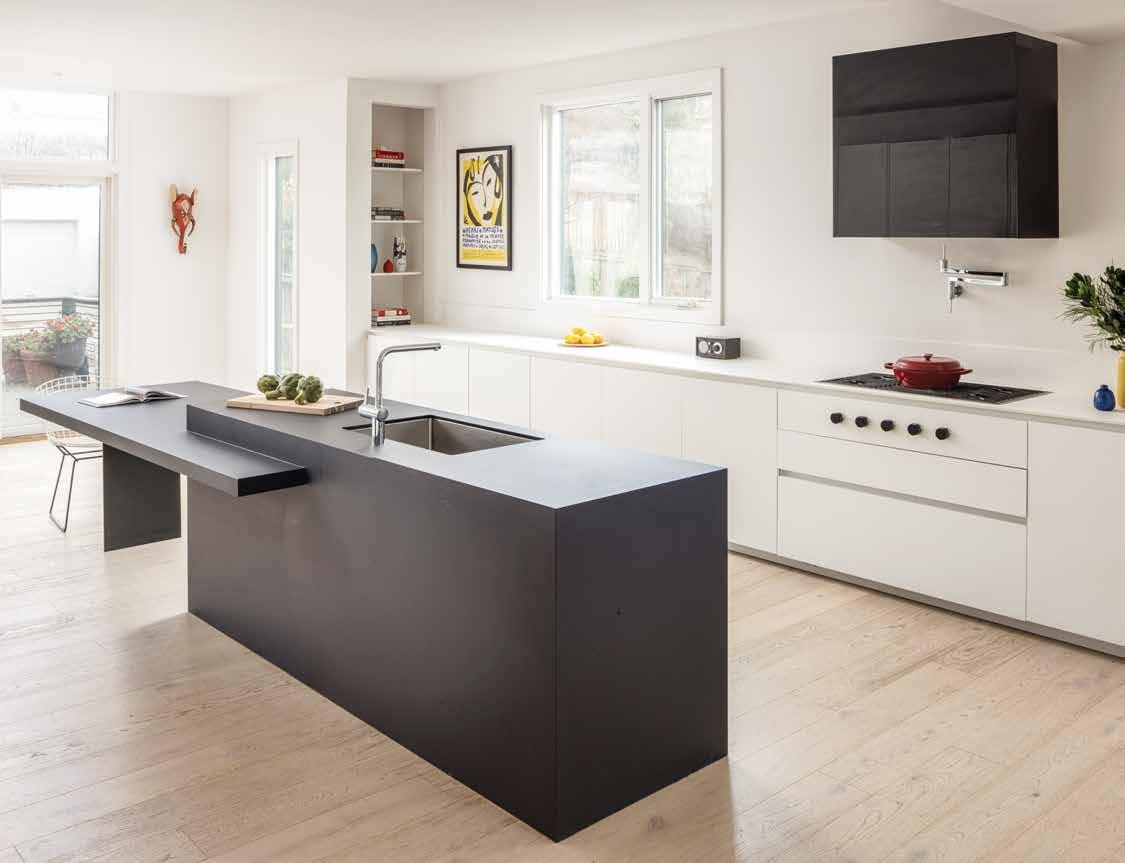White kitchen with a dark grey island and a black hood on the wall