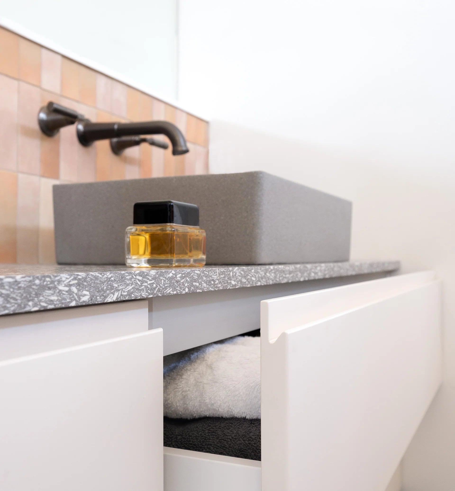 Wide basin on the vanity with a red vase