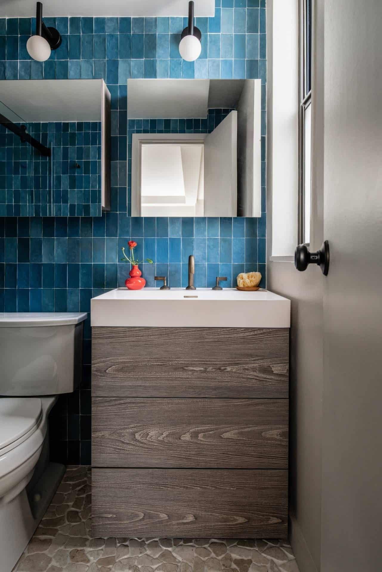 Taupe wall-hung vanity with a lit mirror and blue hydrangeas