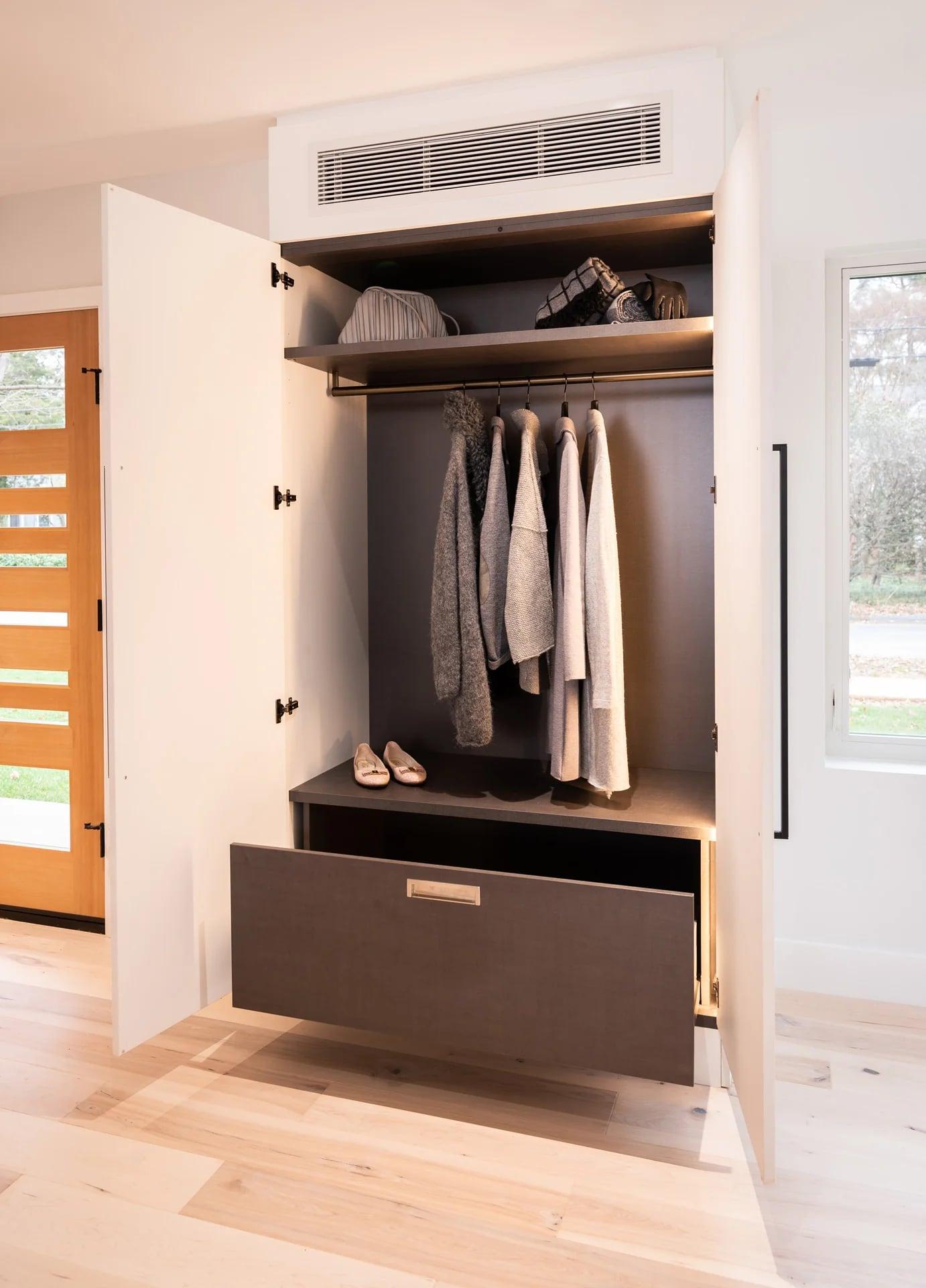 Pale wood base cabinets with white wall units and a yellow vase