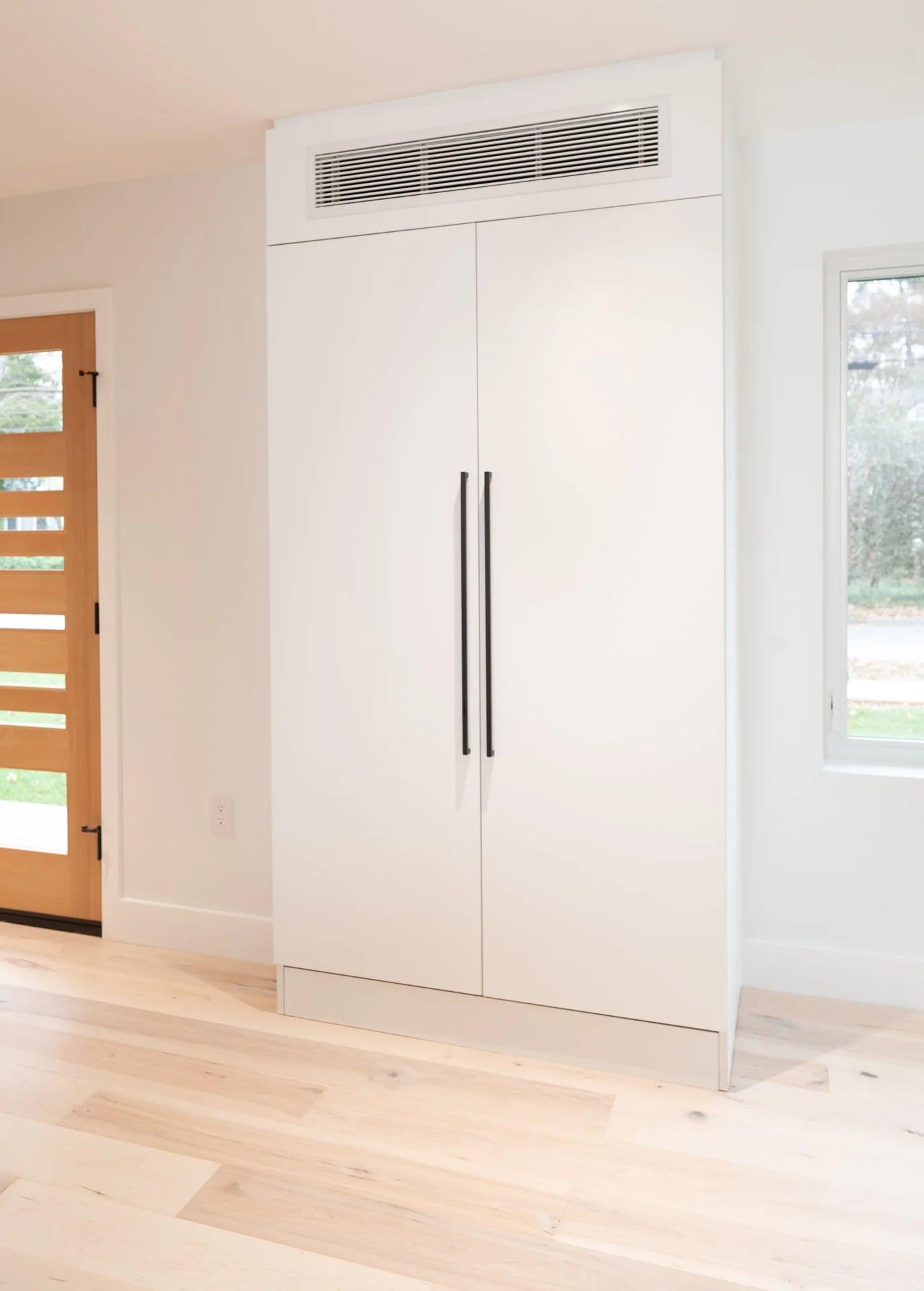 The same cabinets with a door open showing towels