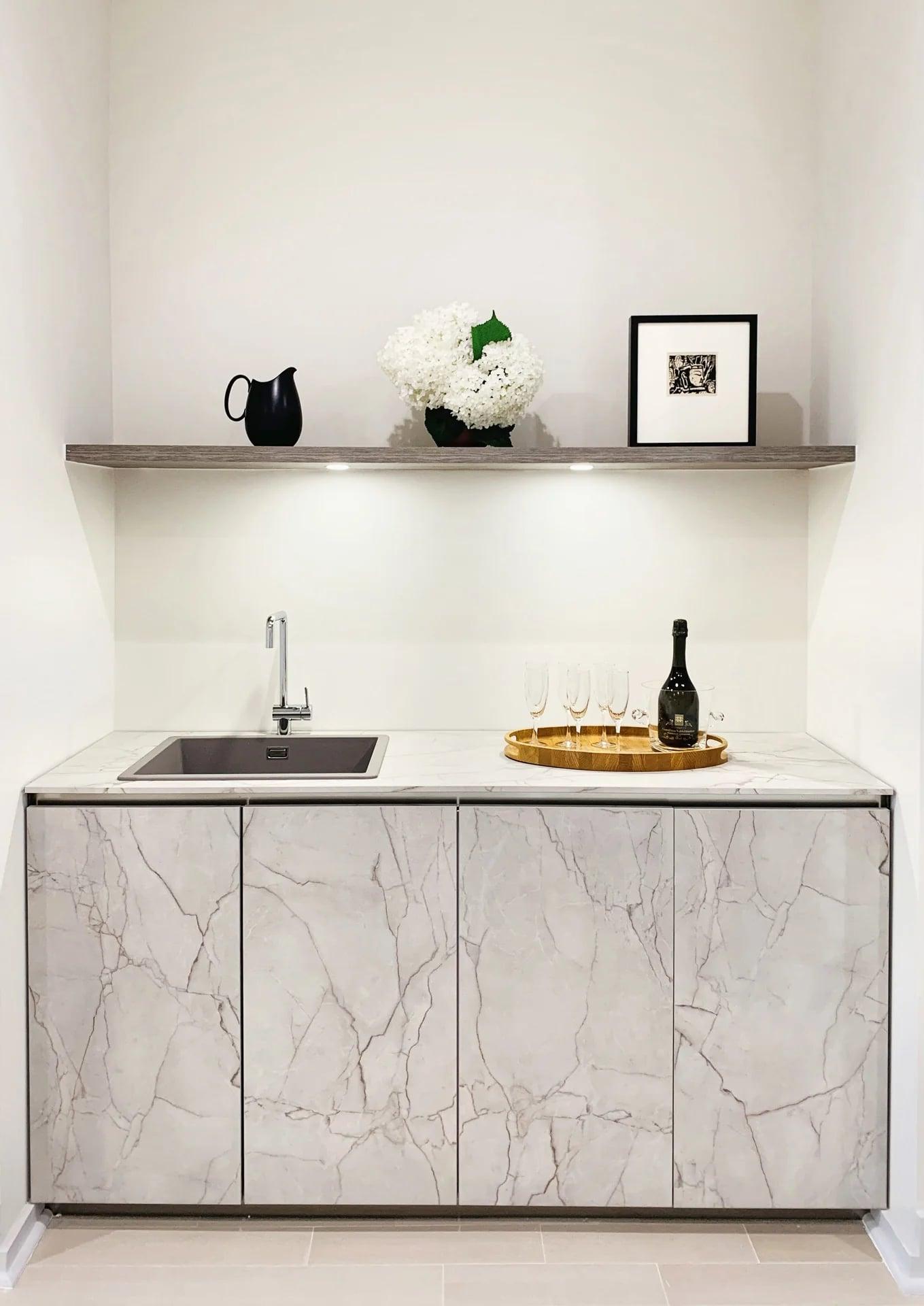 White open bookcase dividing a living room from the stairs