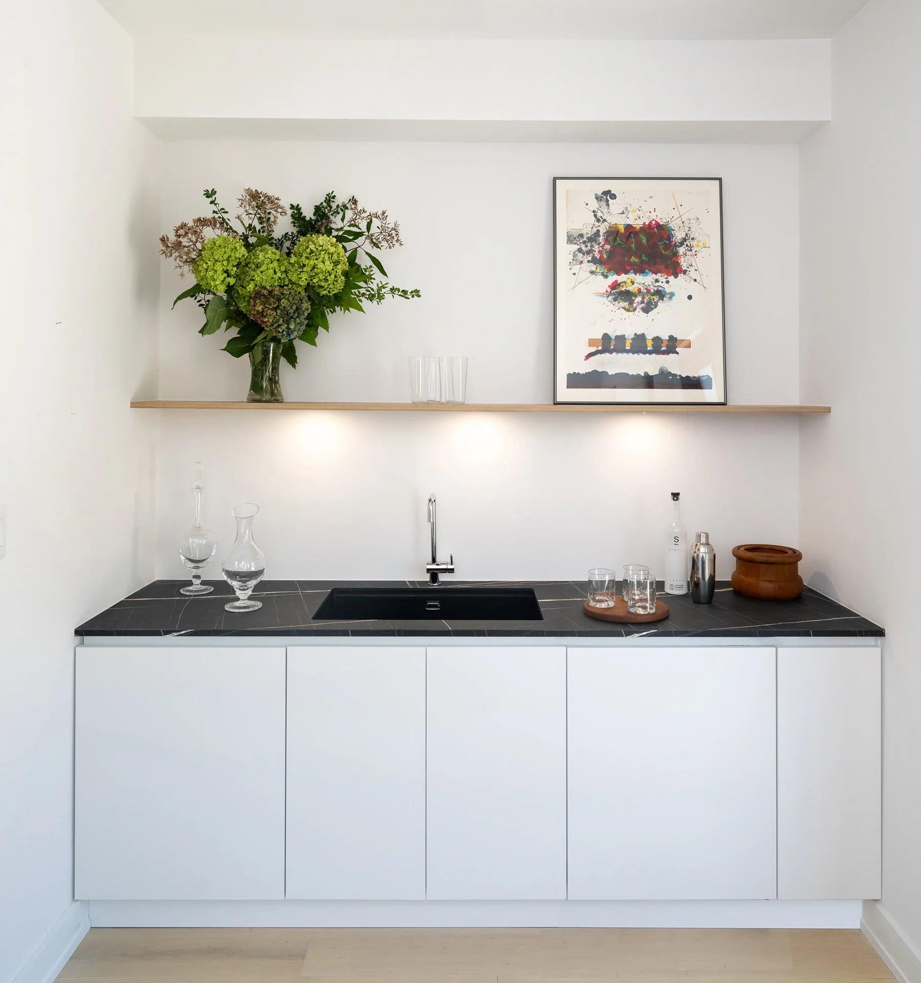 White laundry counter with a sink and baskets