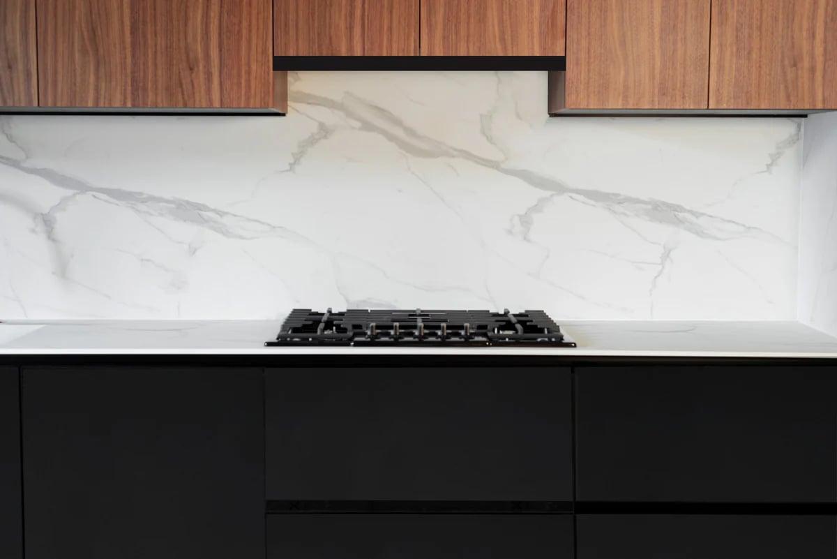 White handleless run with a Fenix worktop and a small dining table