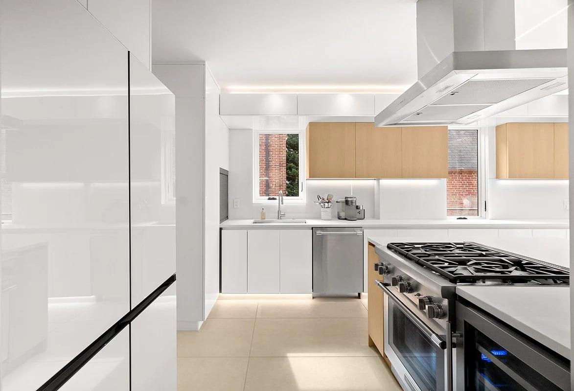 Kitchen with orange wall units and greens on a white island