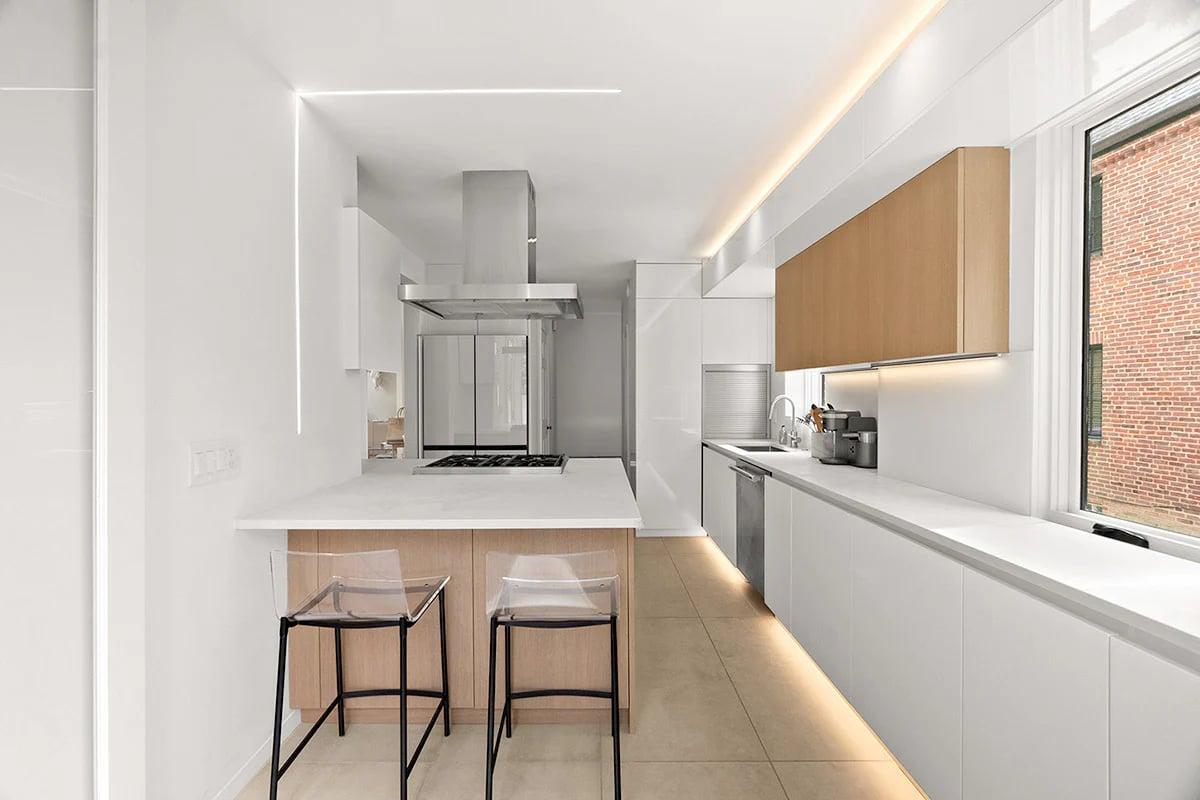 Orange and white kitchen with a small dining table