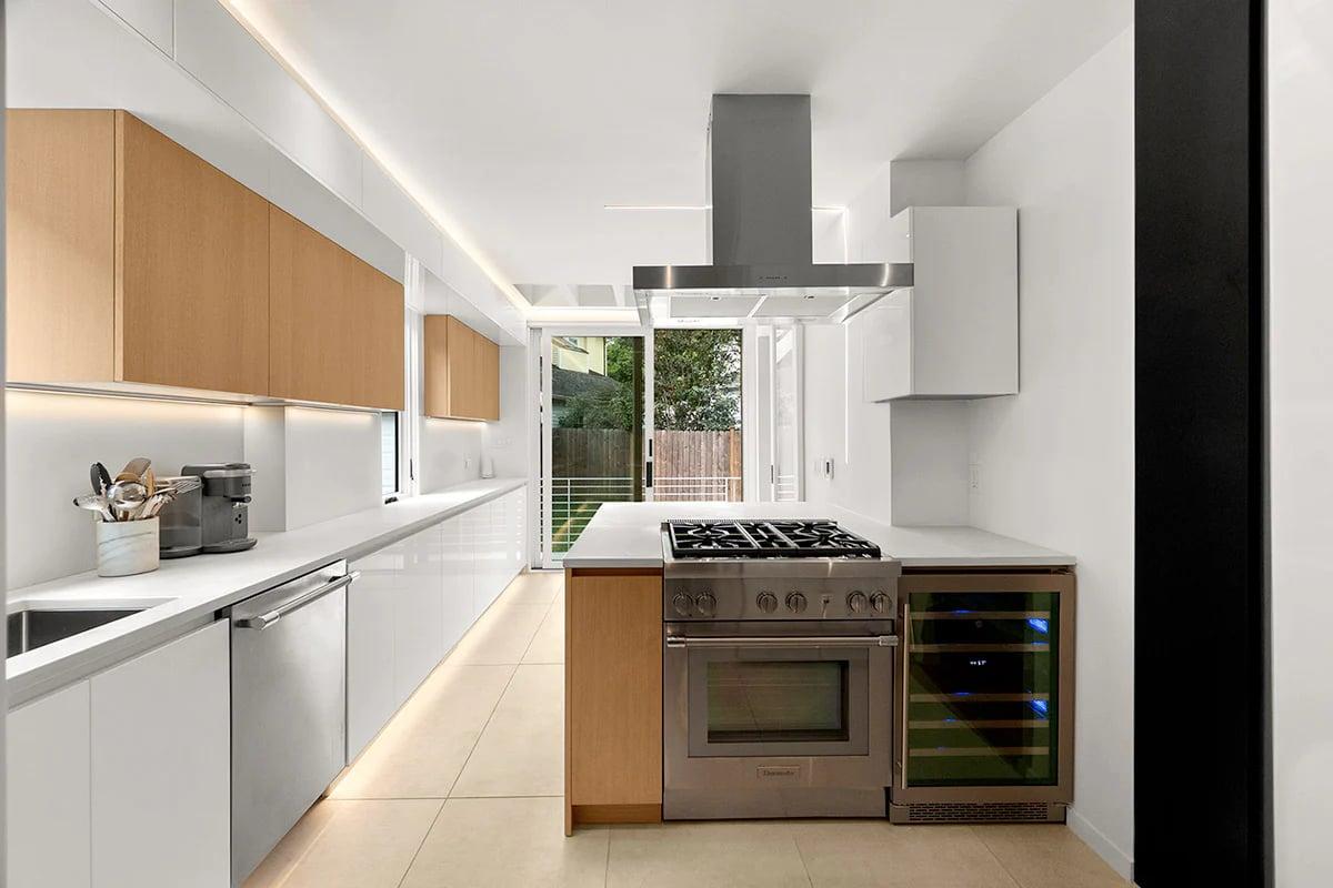 Orange units and a marble splashback beside a window