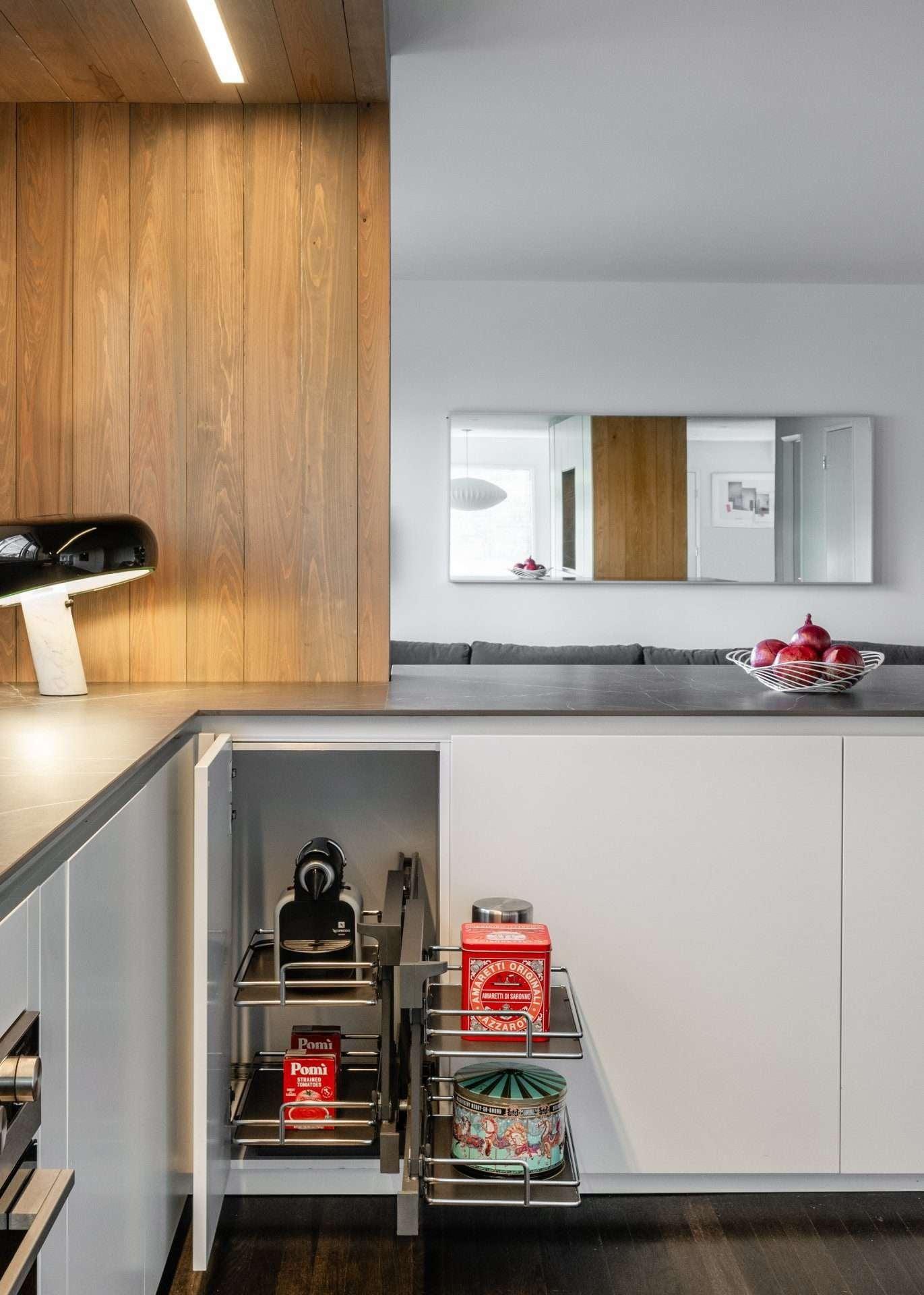 Corner unit in matt white with a wood-clad column and open pull-out