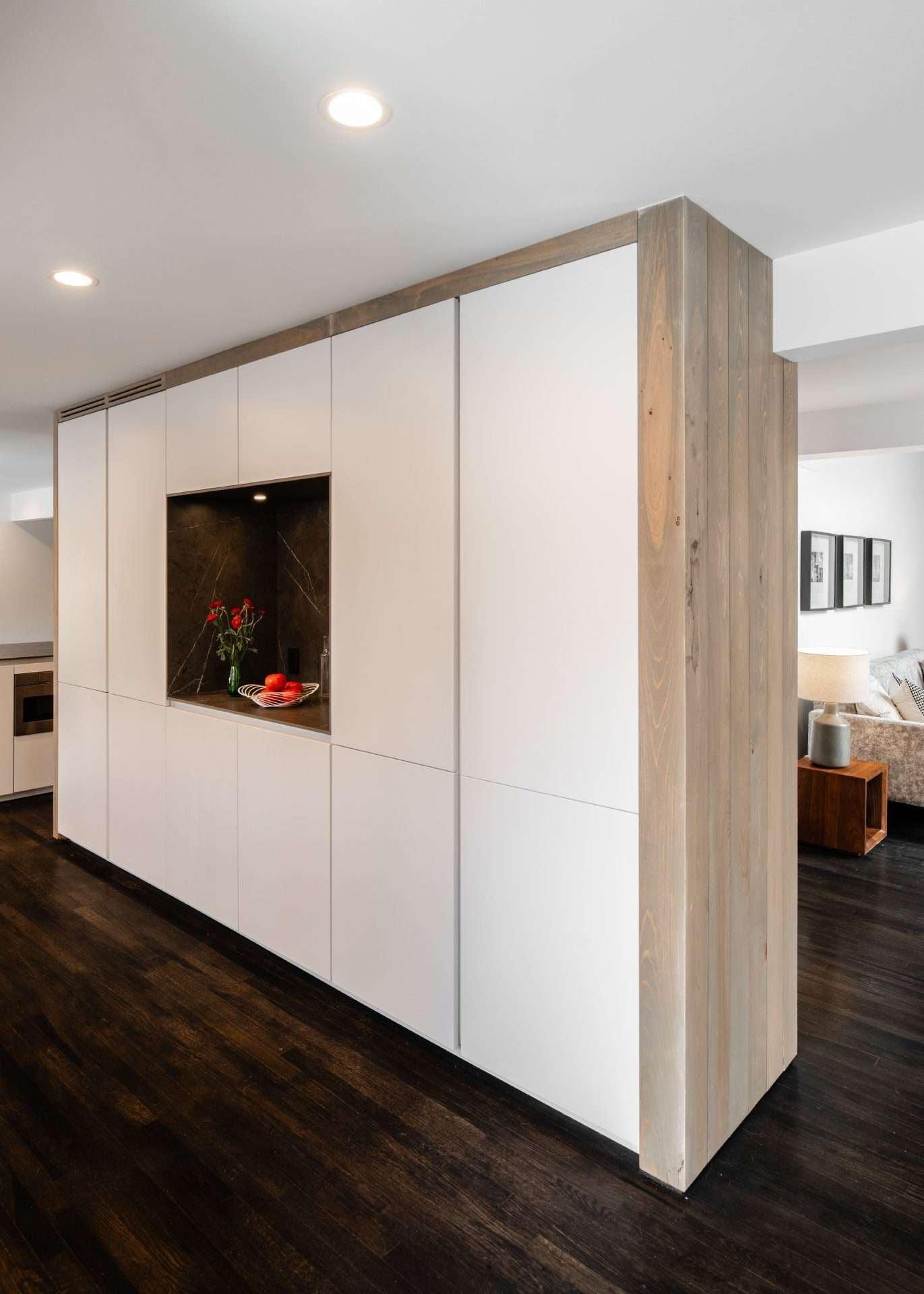 Tall white cabinet wall with a wood-framed niche