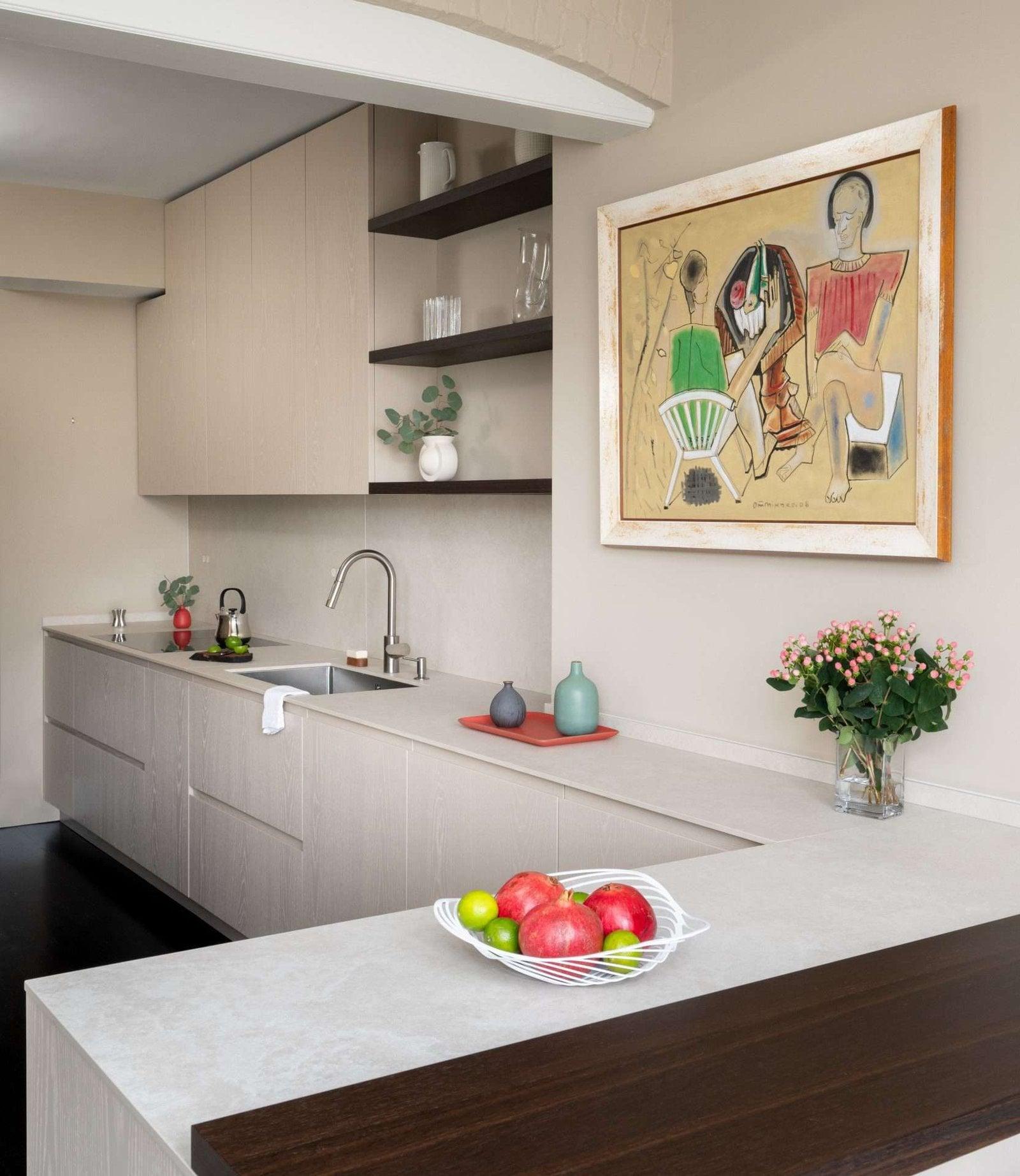 Kitchen seen from the living room with two pink armchairs