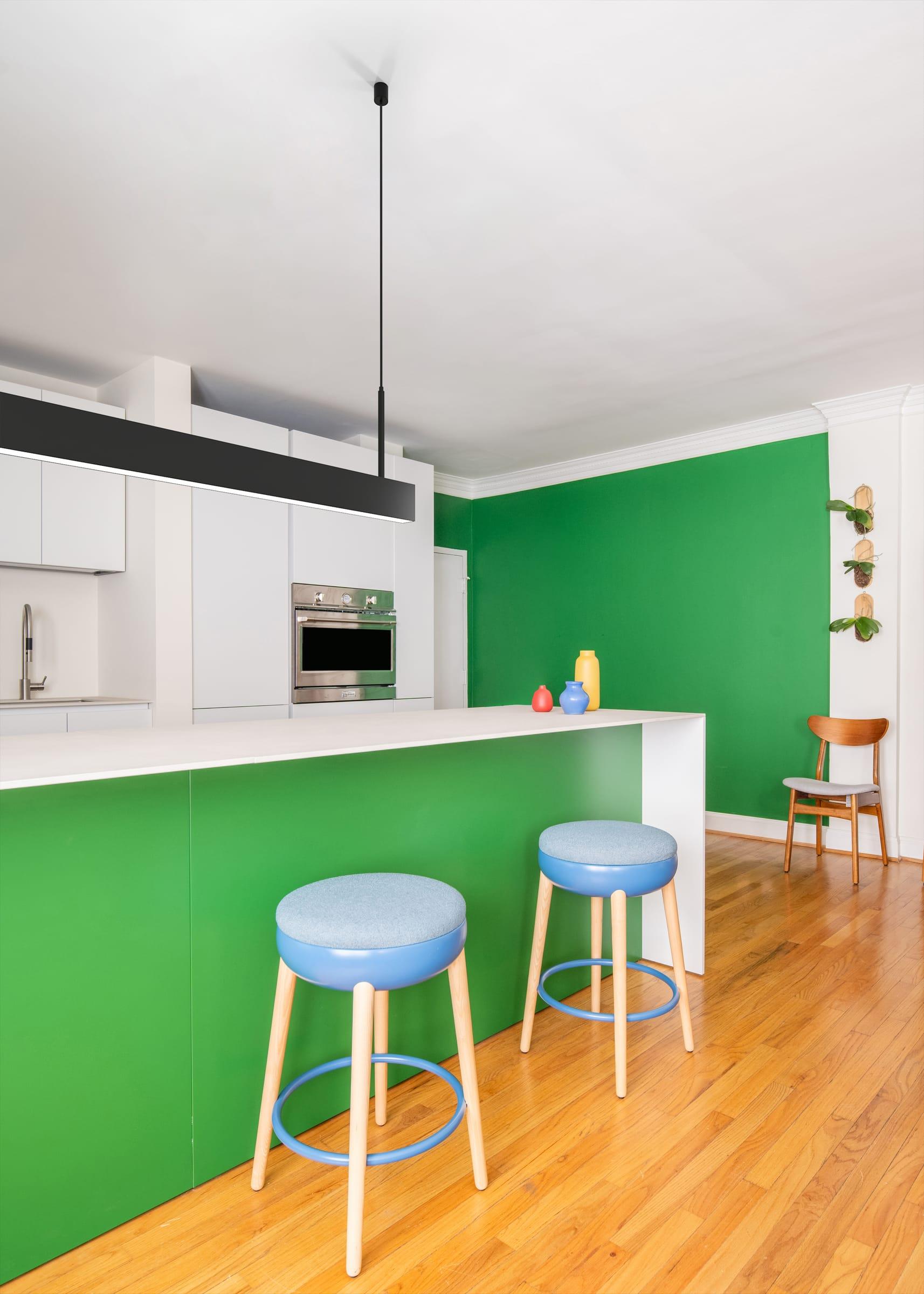 Green island with blue stools and a green wall