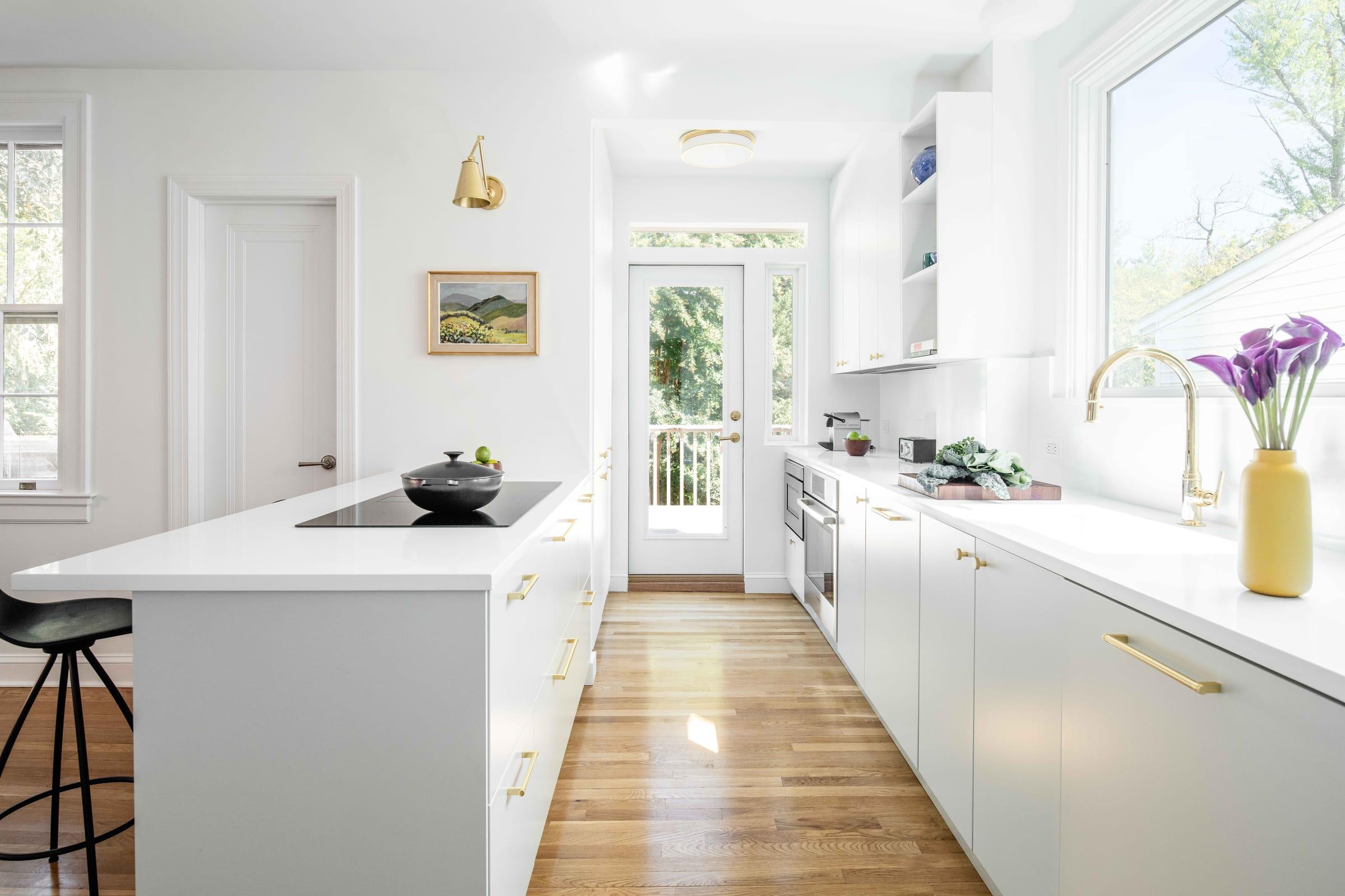 White galley kitchen with a hob island and a glazed door