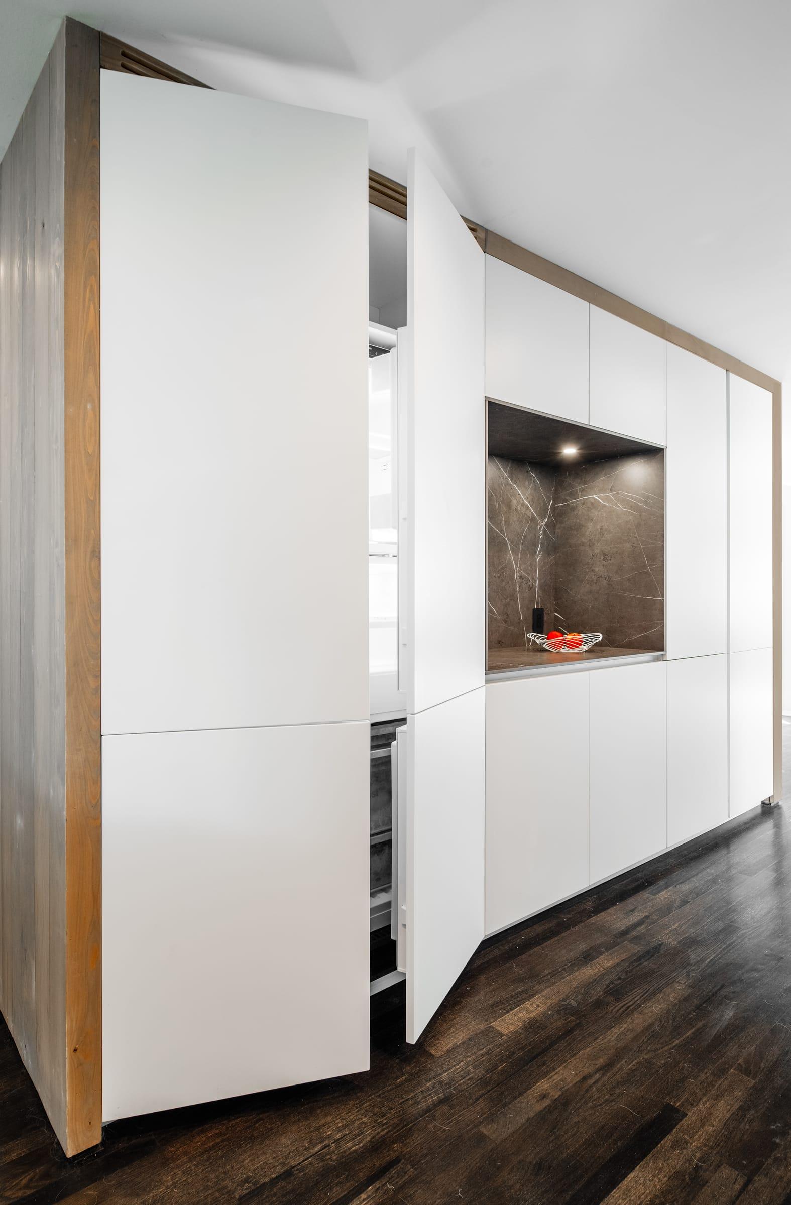 White tall units opening from a wood-clad wall