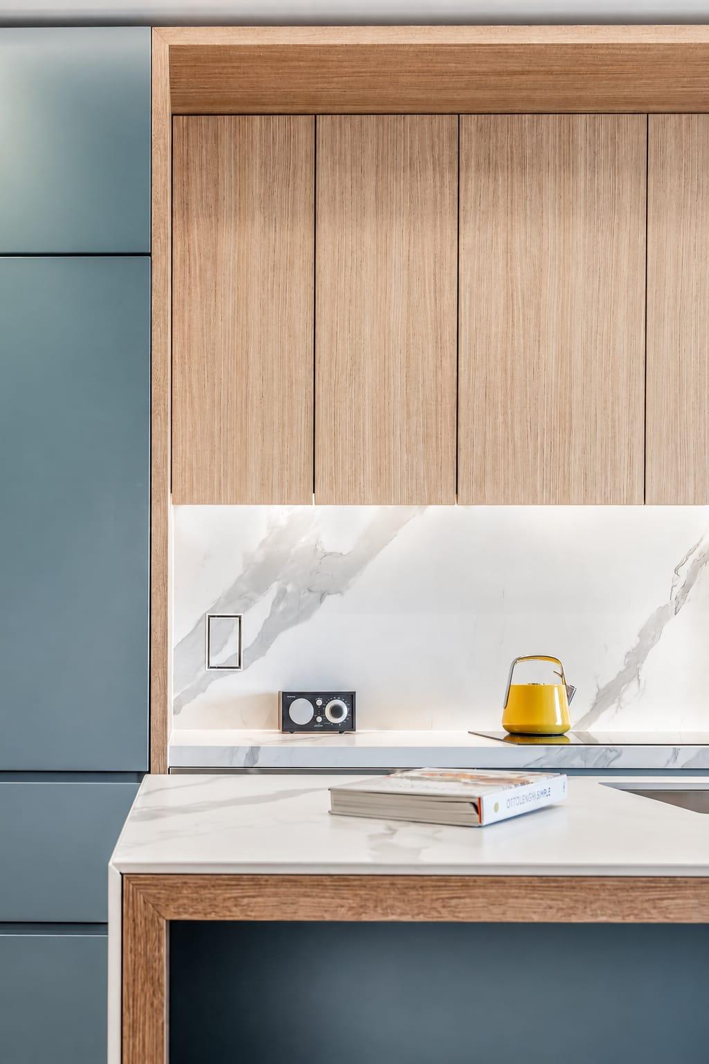 Oak wall cabinets over a marble splashback