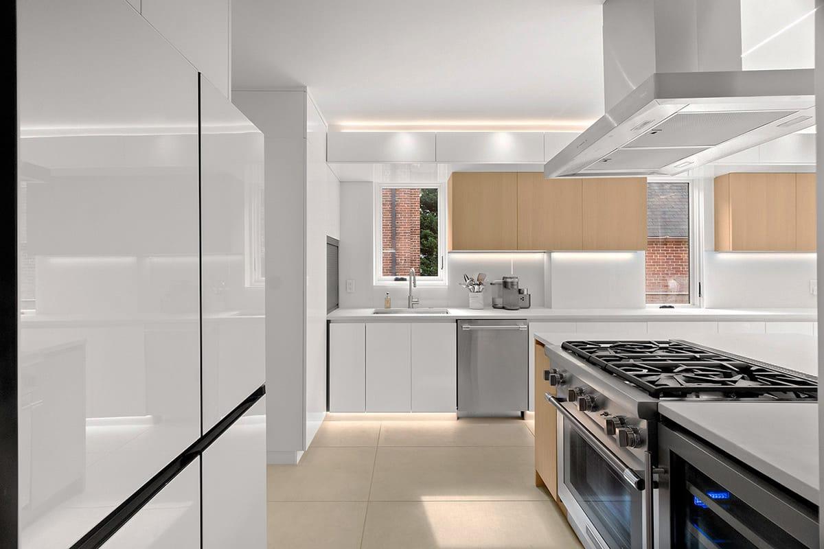 White kitchen with a range and a steel hood
