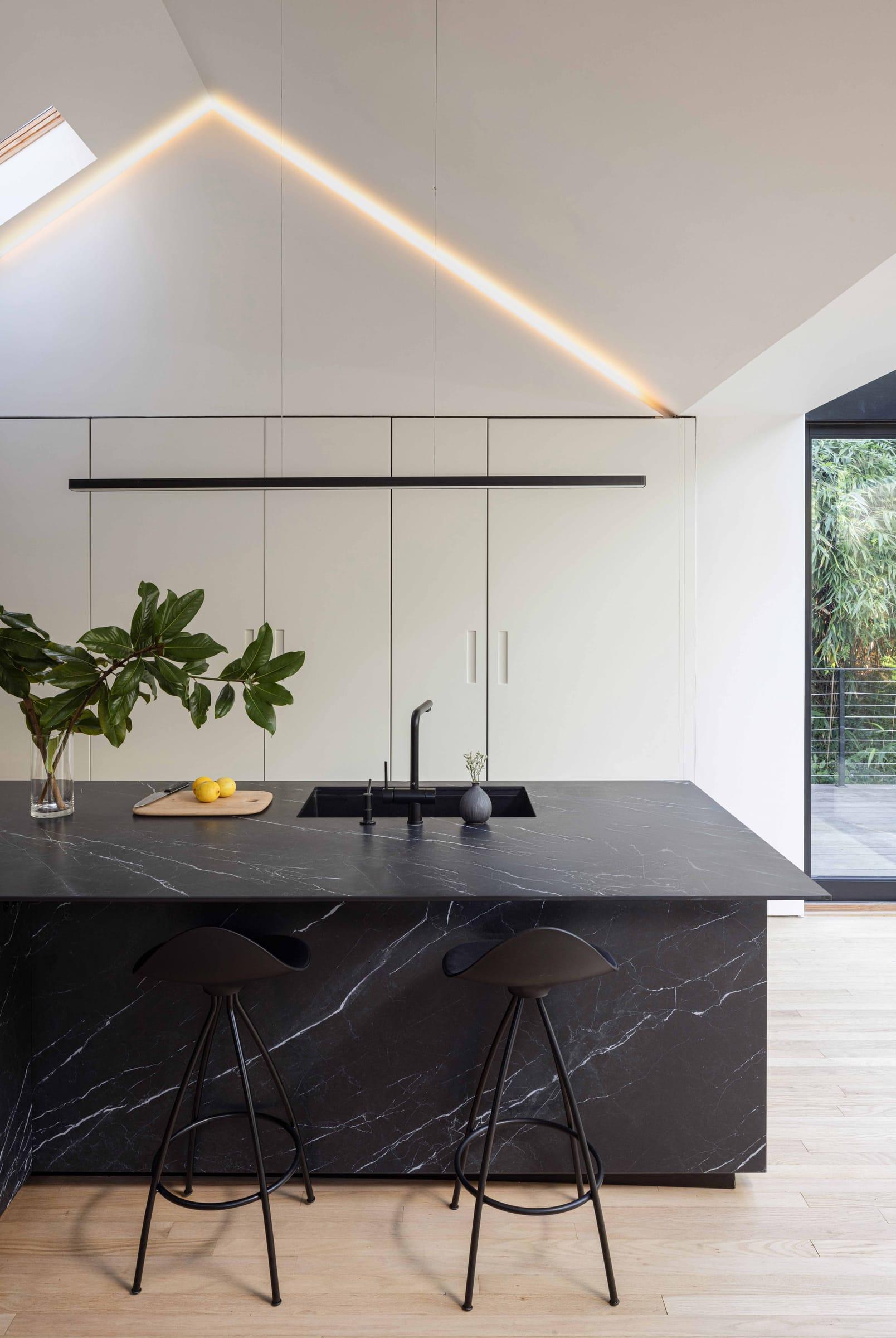 Black marble island with two stools under the vaulted ceiling