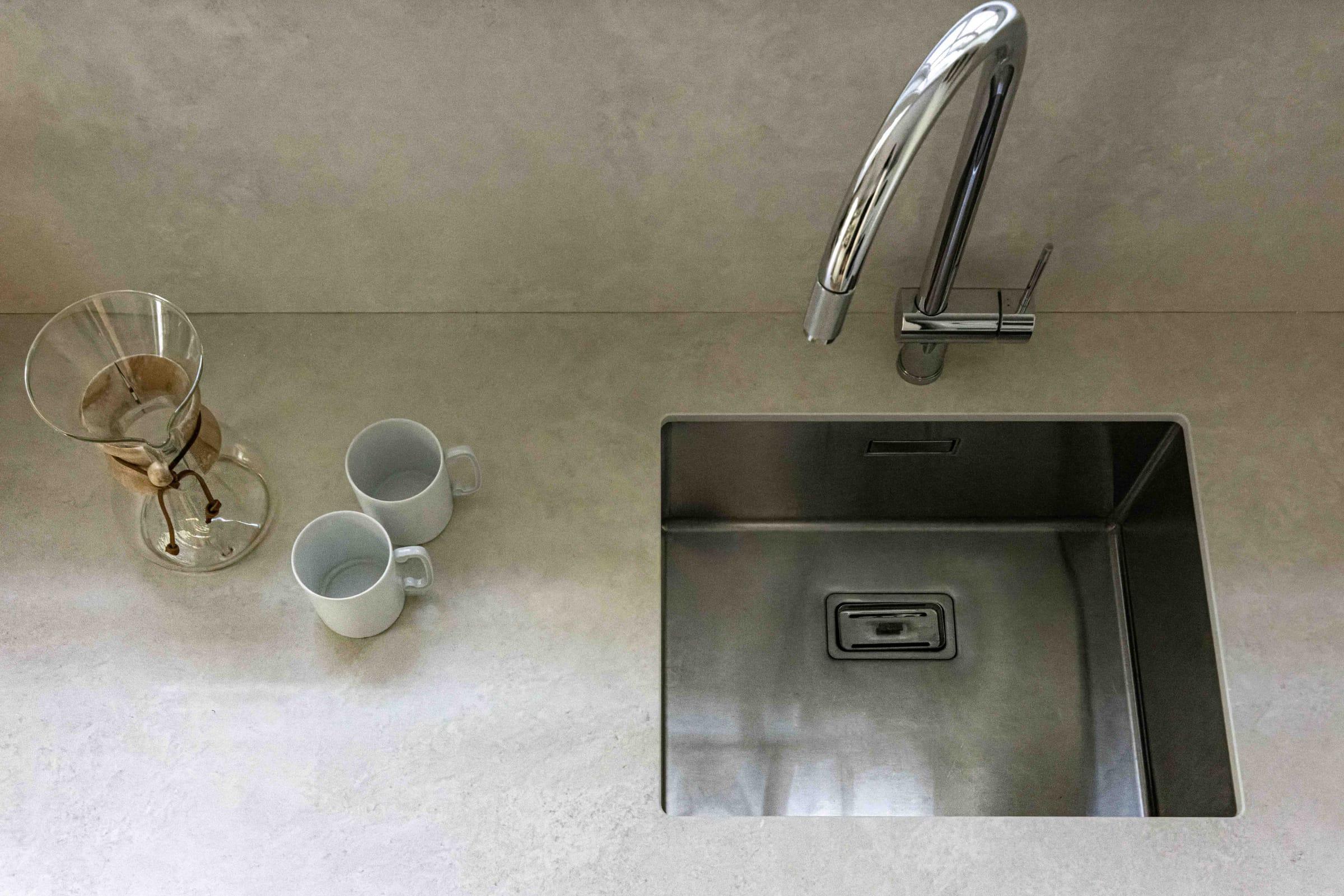 Steel sink in a pale stone worktop, seen from above
