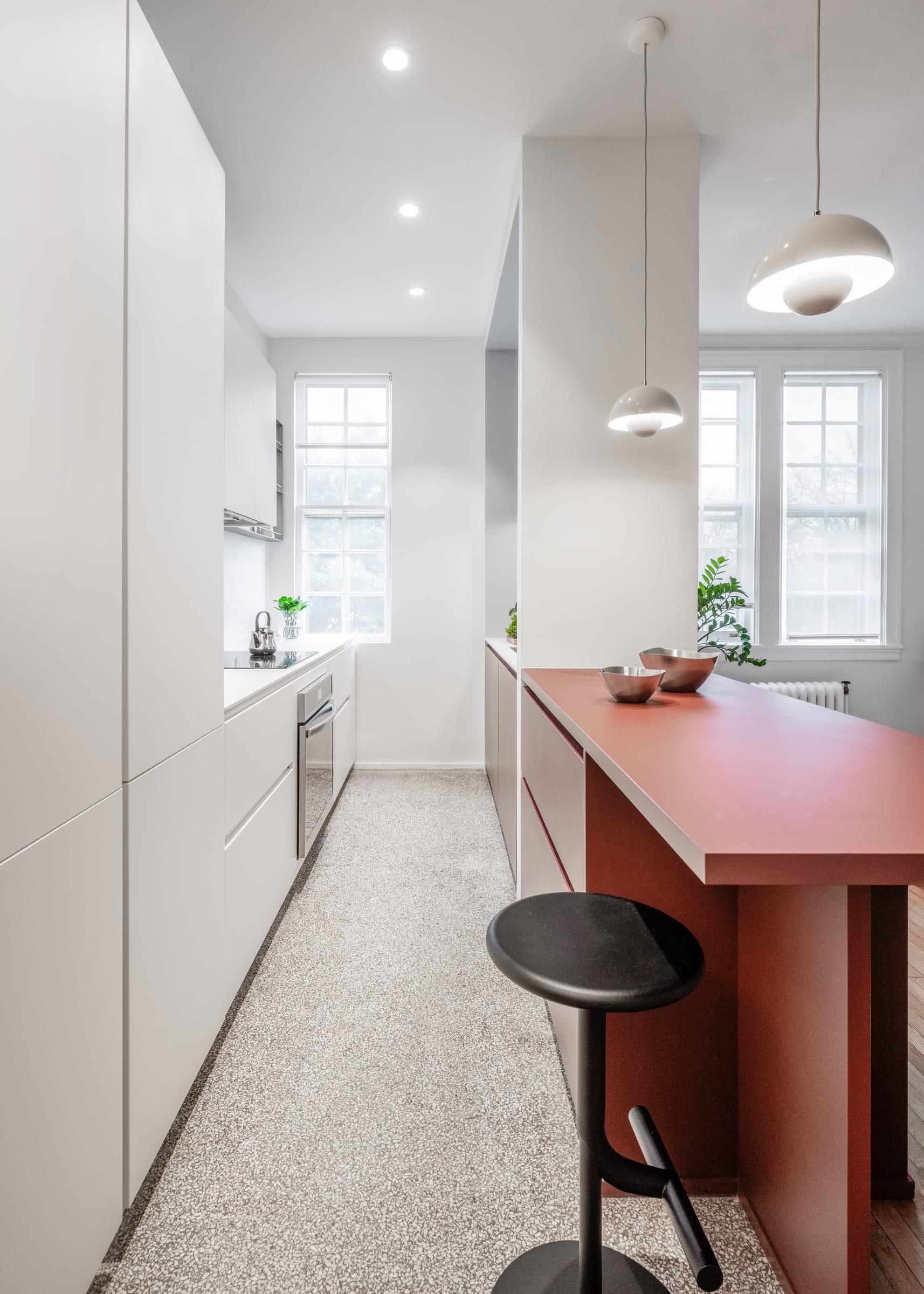 Burgundy island along a white galley kitchen