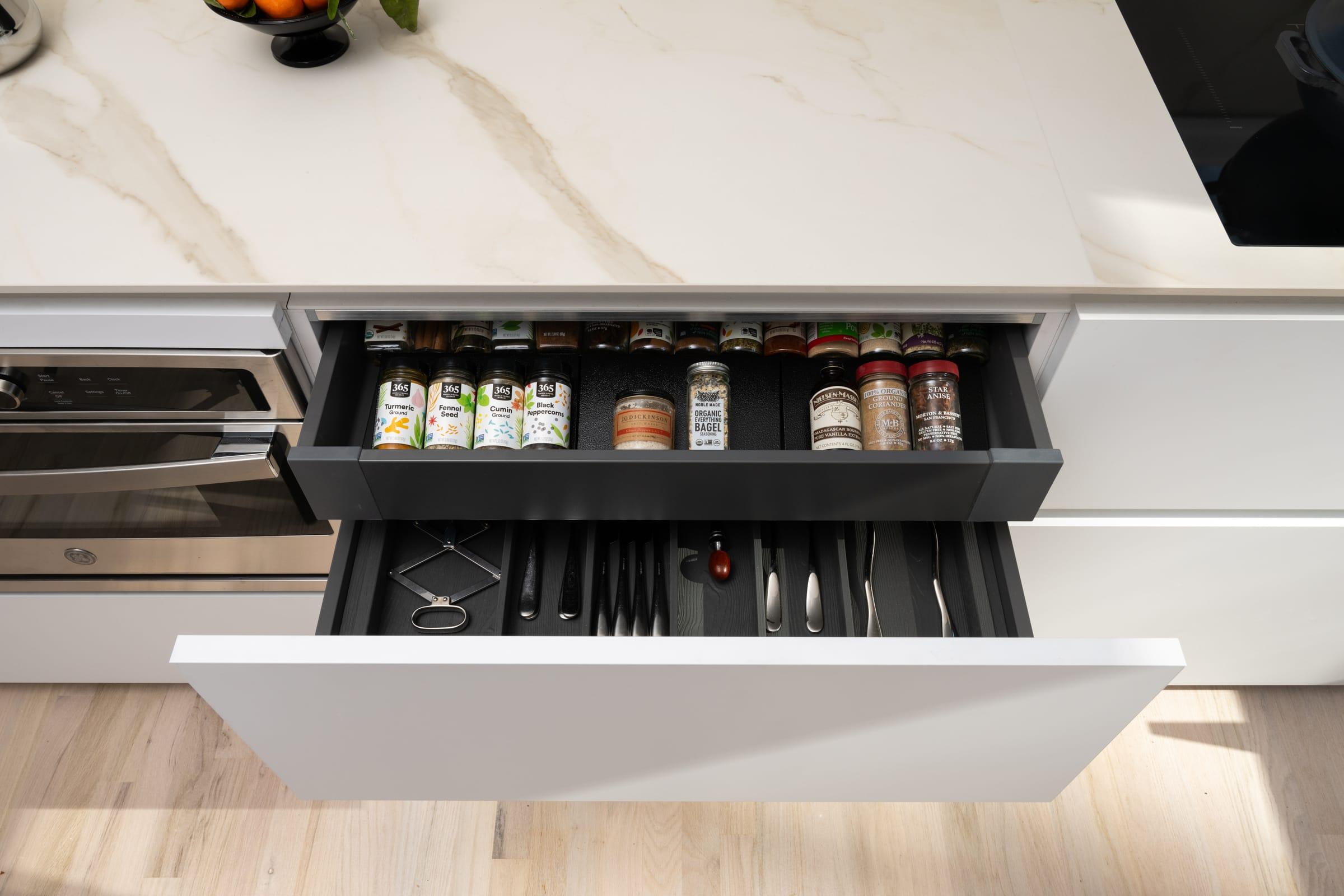 Open spice drawer under a marble worktop