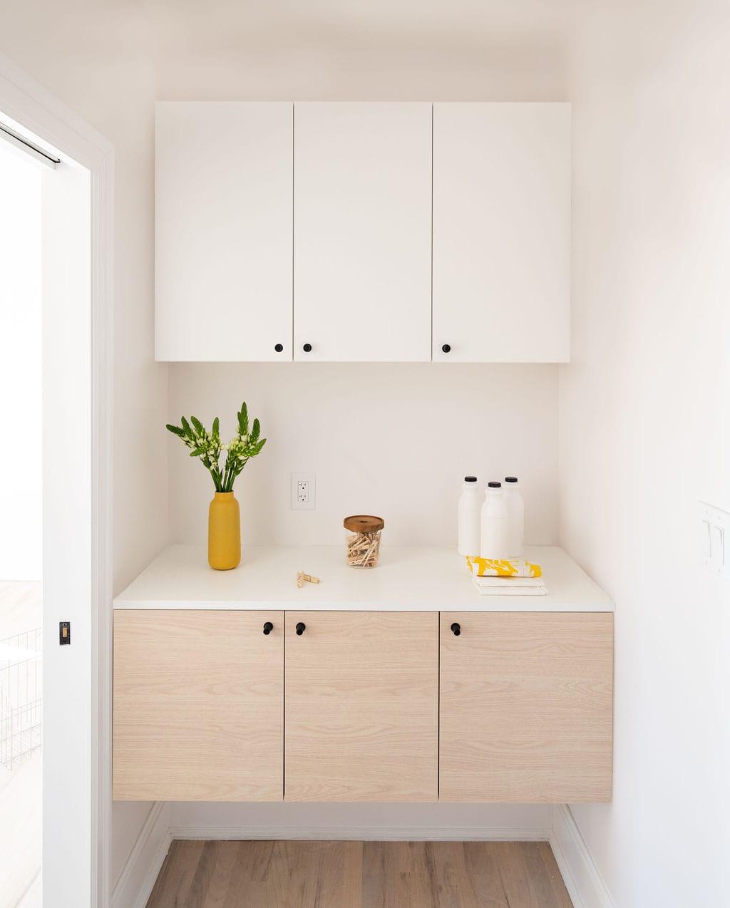 Oak cabinets under white wall units in an alcove