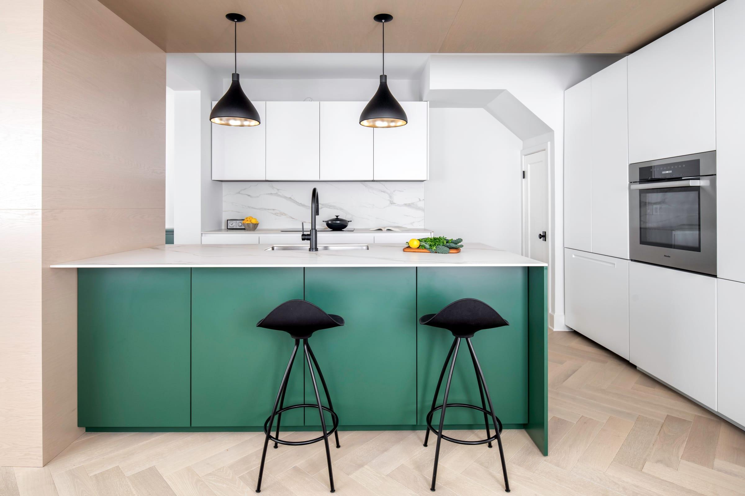 Green island with black stools under black pendants