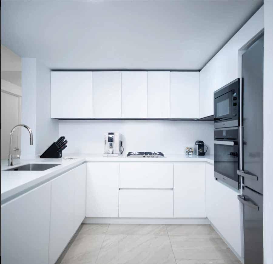 White U-shaped kitchen with tall dark ovens
