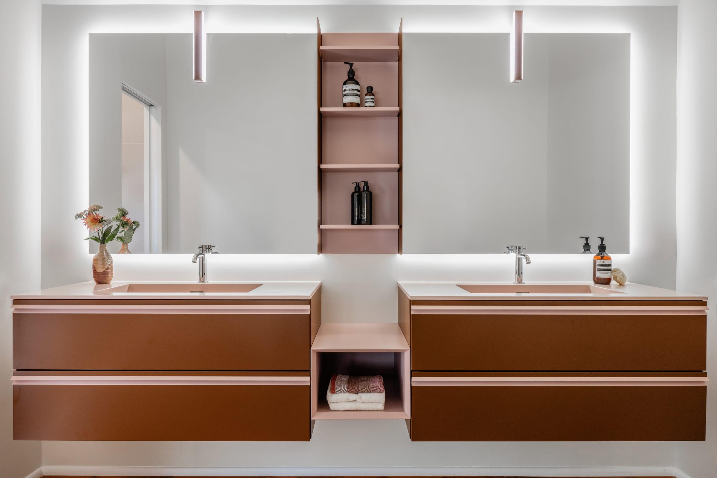 Walnut double vanity under a long lit mirror
