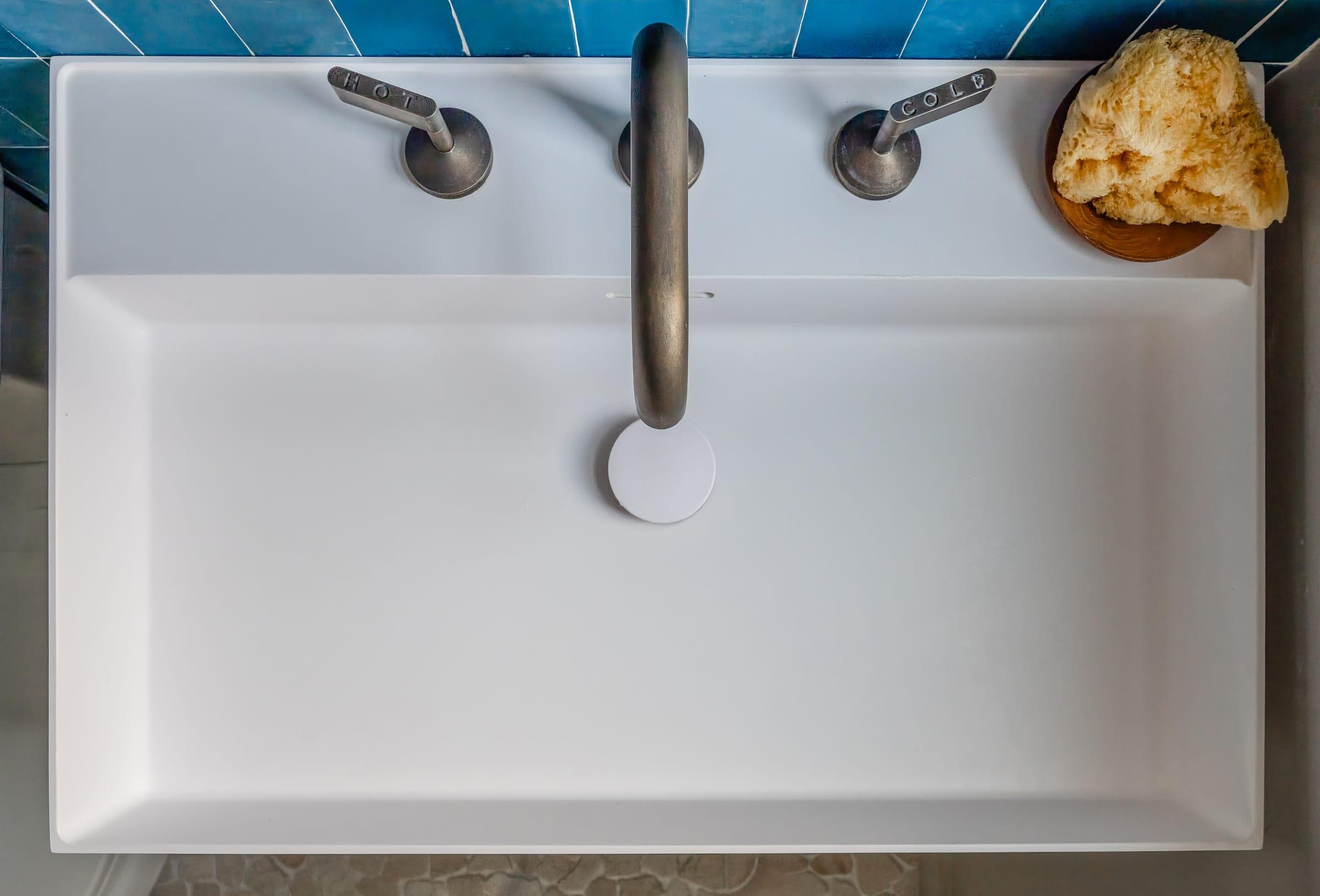 White basin with a bronze tap, seen from above