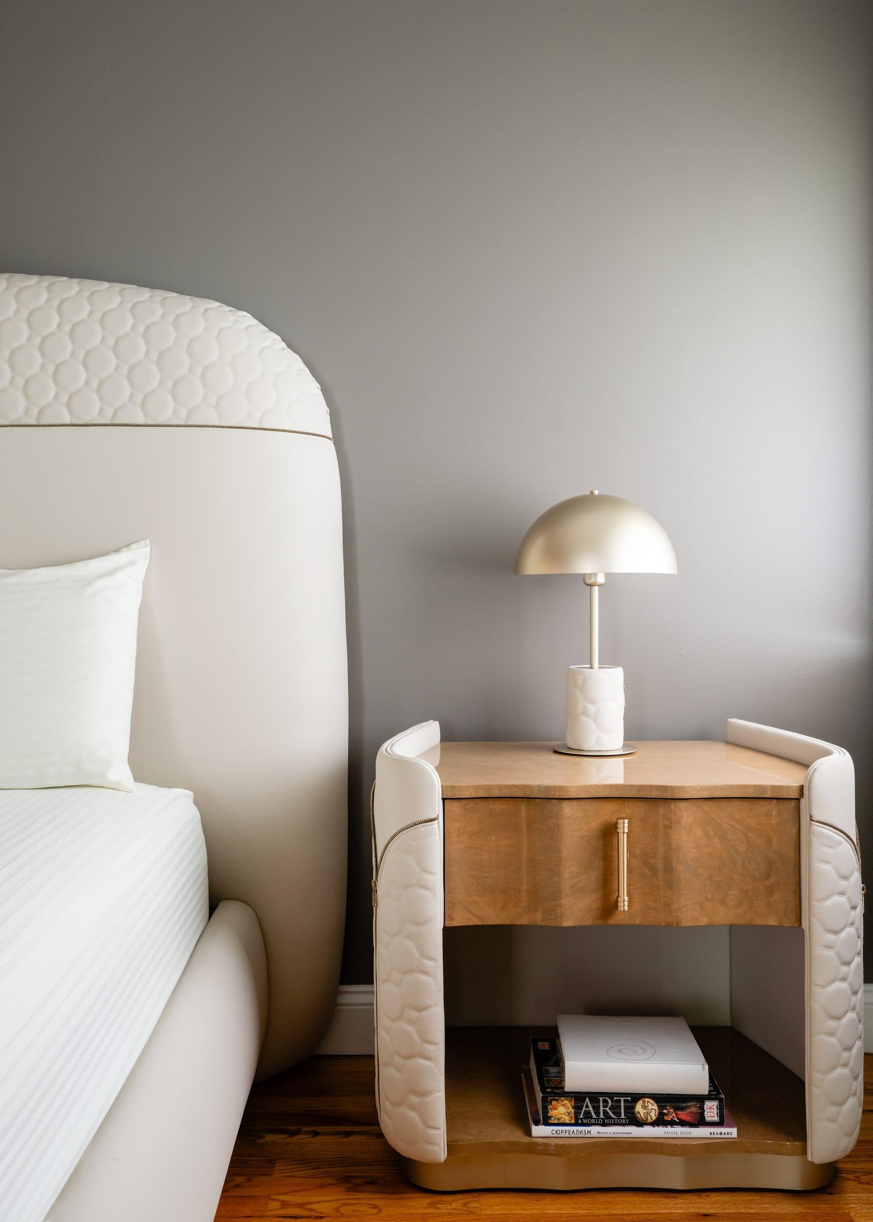 Floating bedside table with a lamp beside an upholstered bed