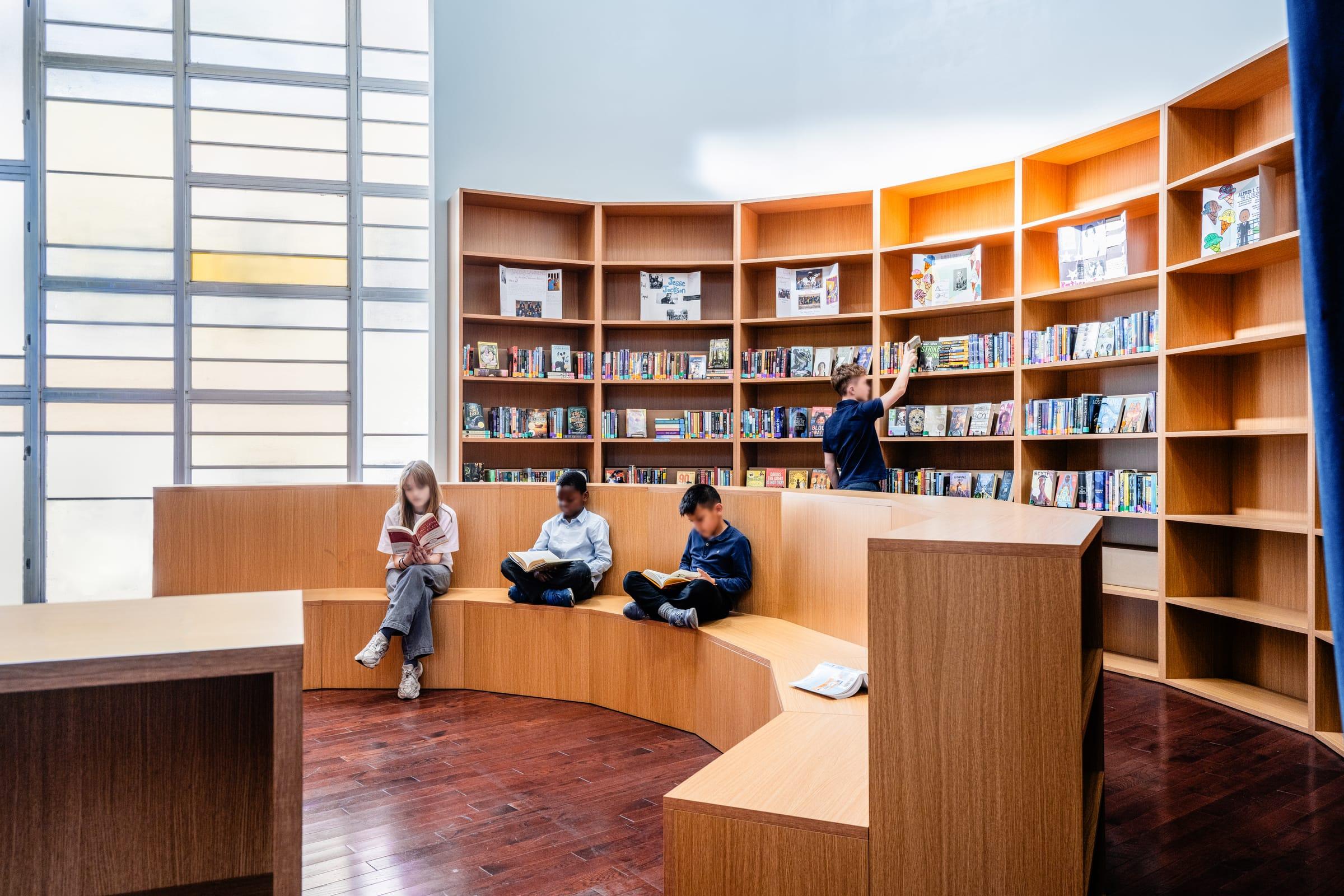 Curved wood shelves and benches by a tall window