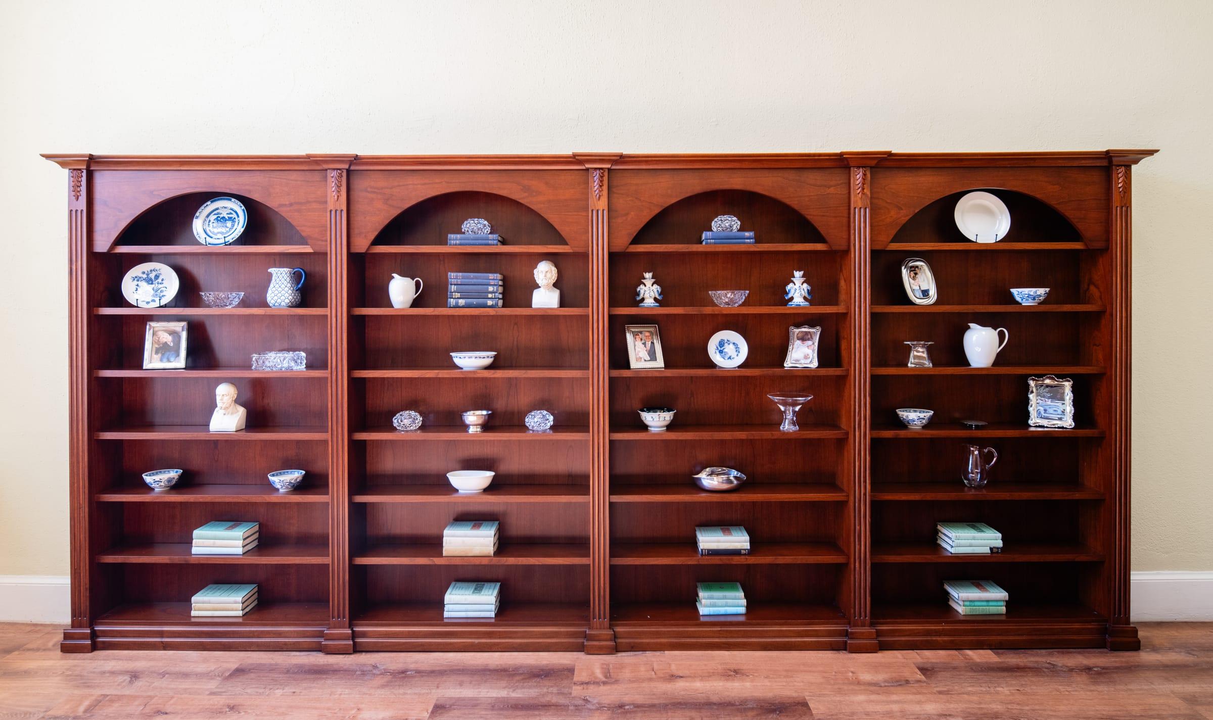 Cherry wood bookcase with arched niches holding china