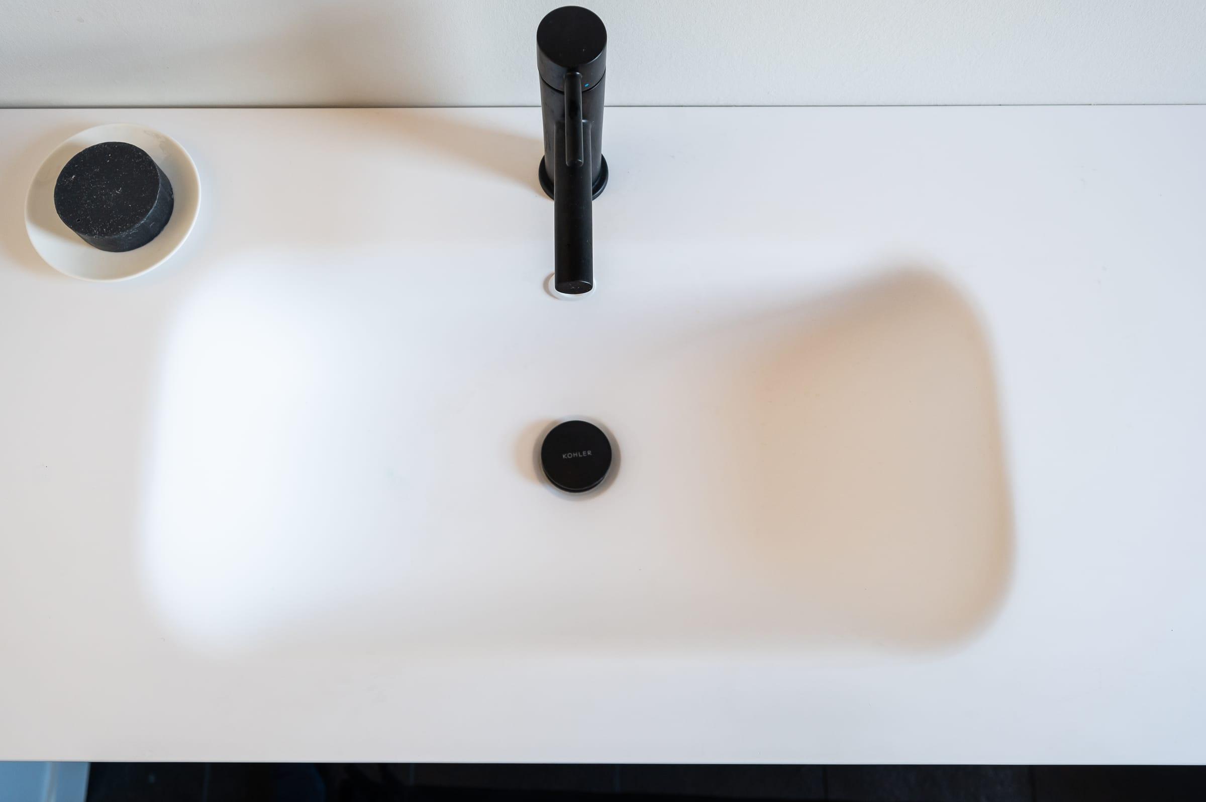 White basin with a black tap, seen from above