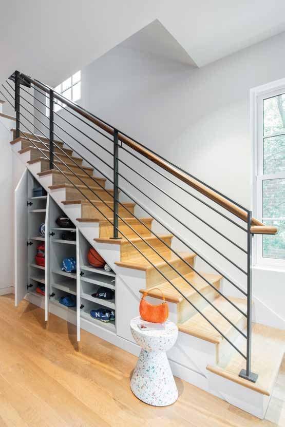 Open shelving built under a staircase with a steel railing
