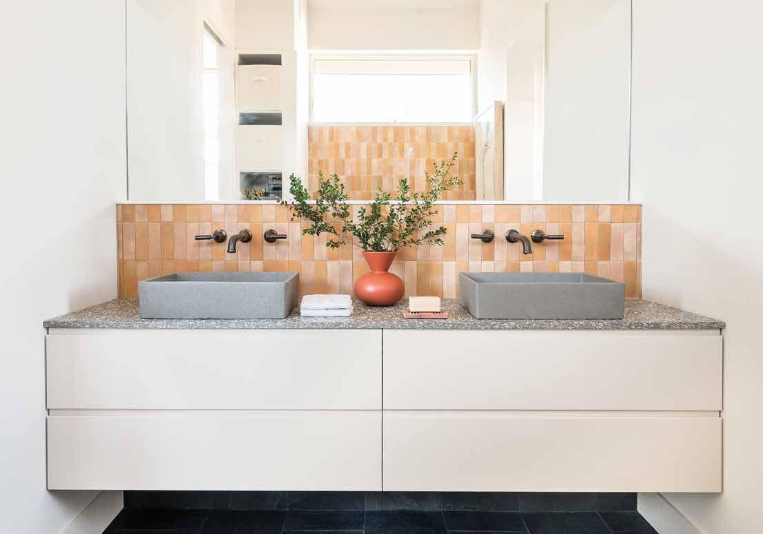 White double vanity with grey basins and a terracotta tiled splashback