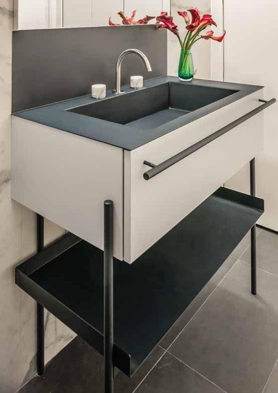 Grey washbasin on an open black steel stand with a towel rail