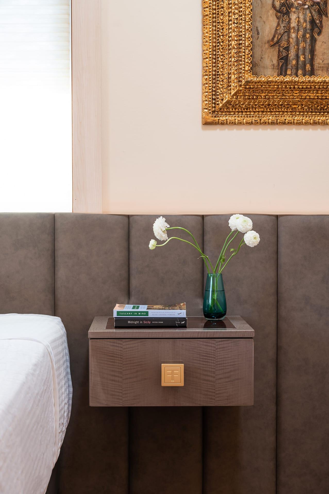 Floating bedside drawer against an upholstered headboard wall