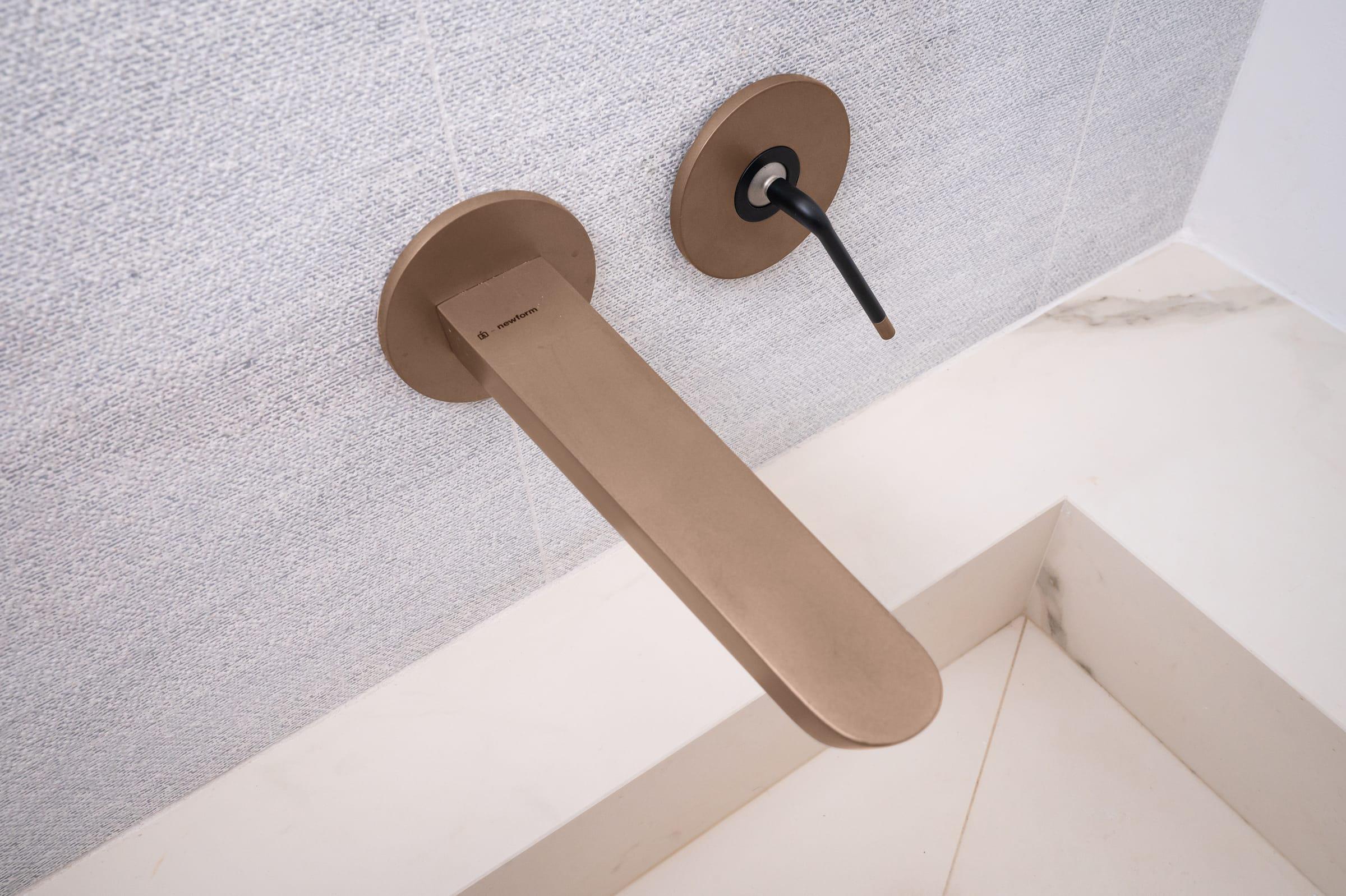 Copper wall tap over a marble basin