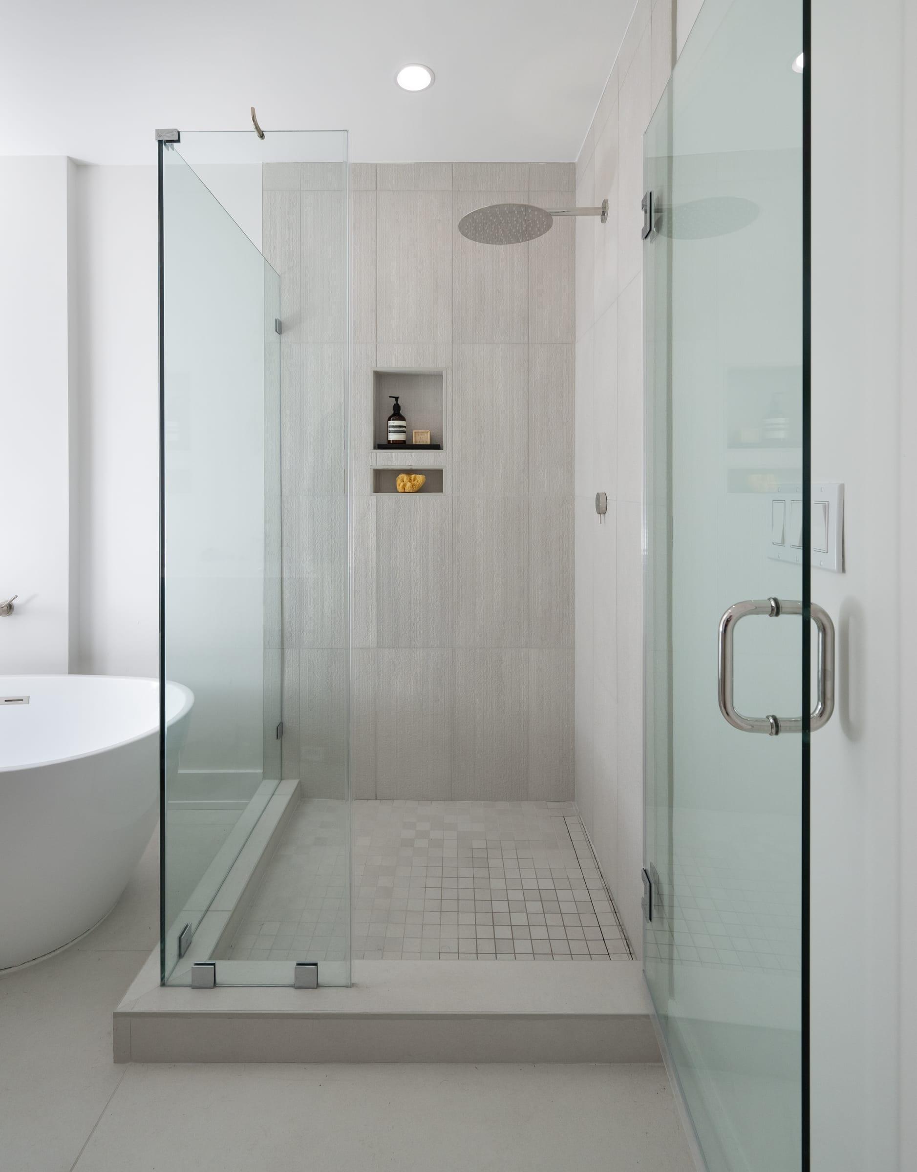 Glass shower beside a freestanding tub