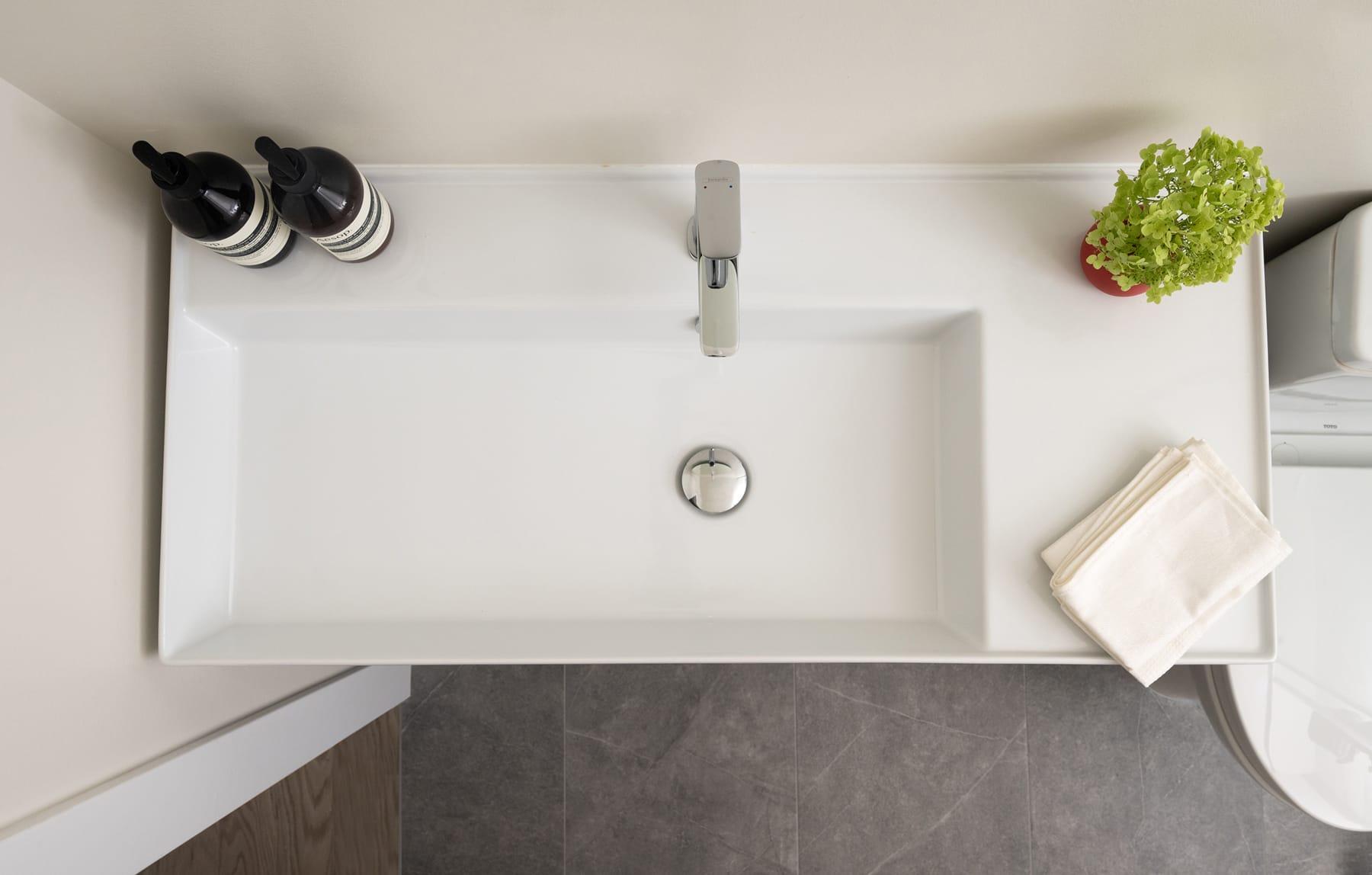 White basin with a slim tap, seen from above