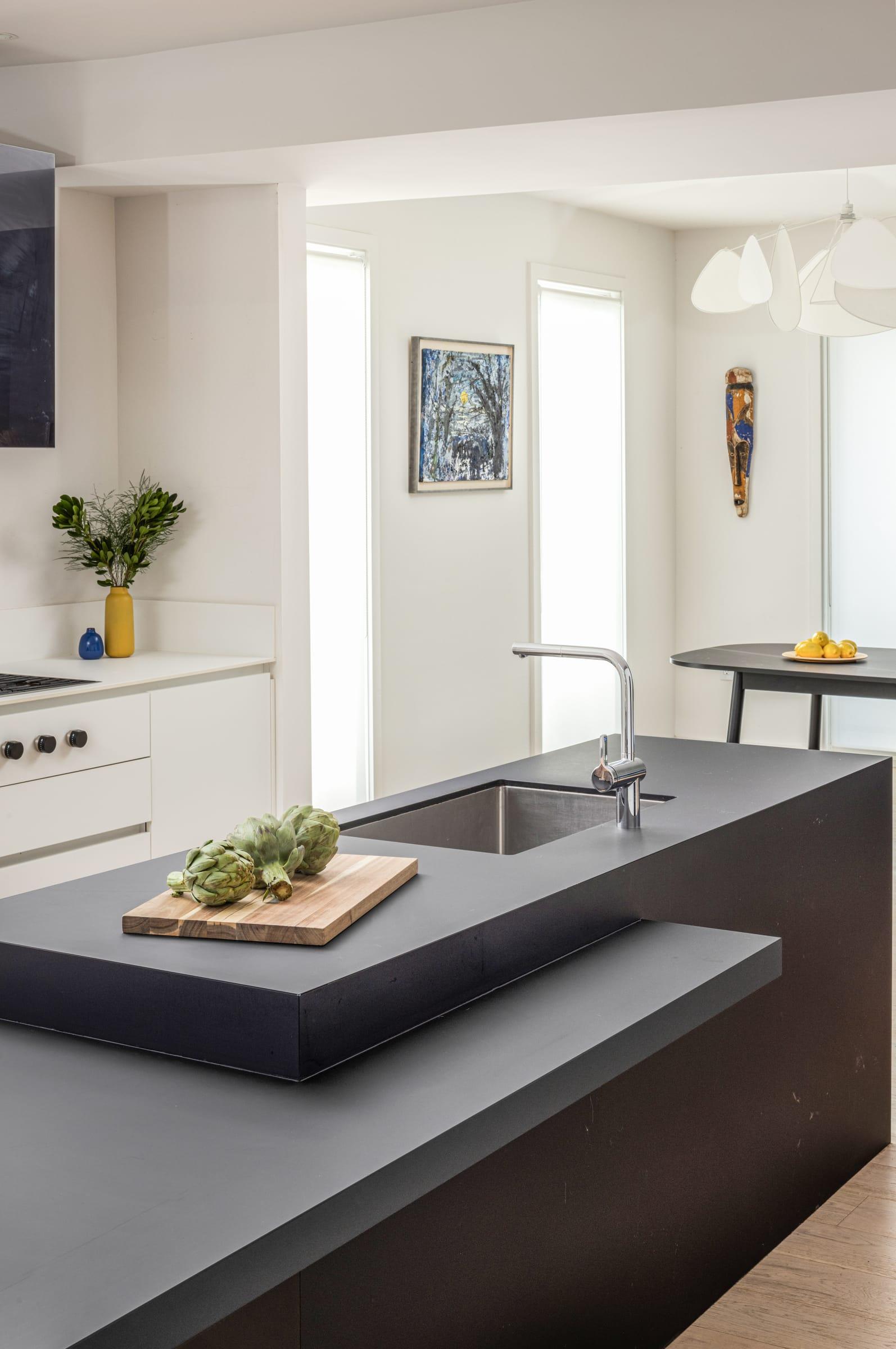 Dark grey island with a chopping board, a window behind