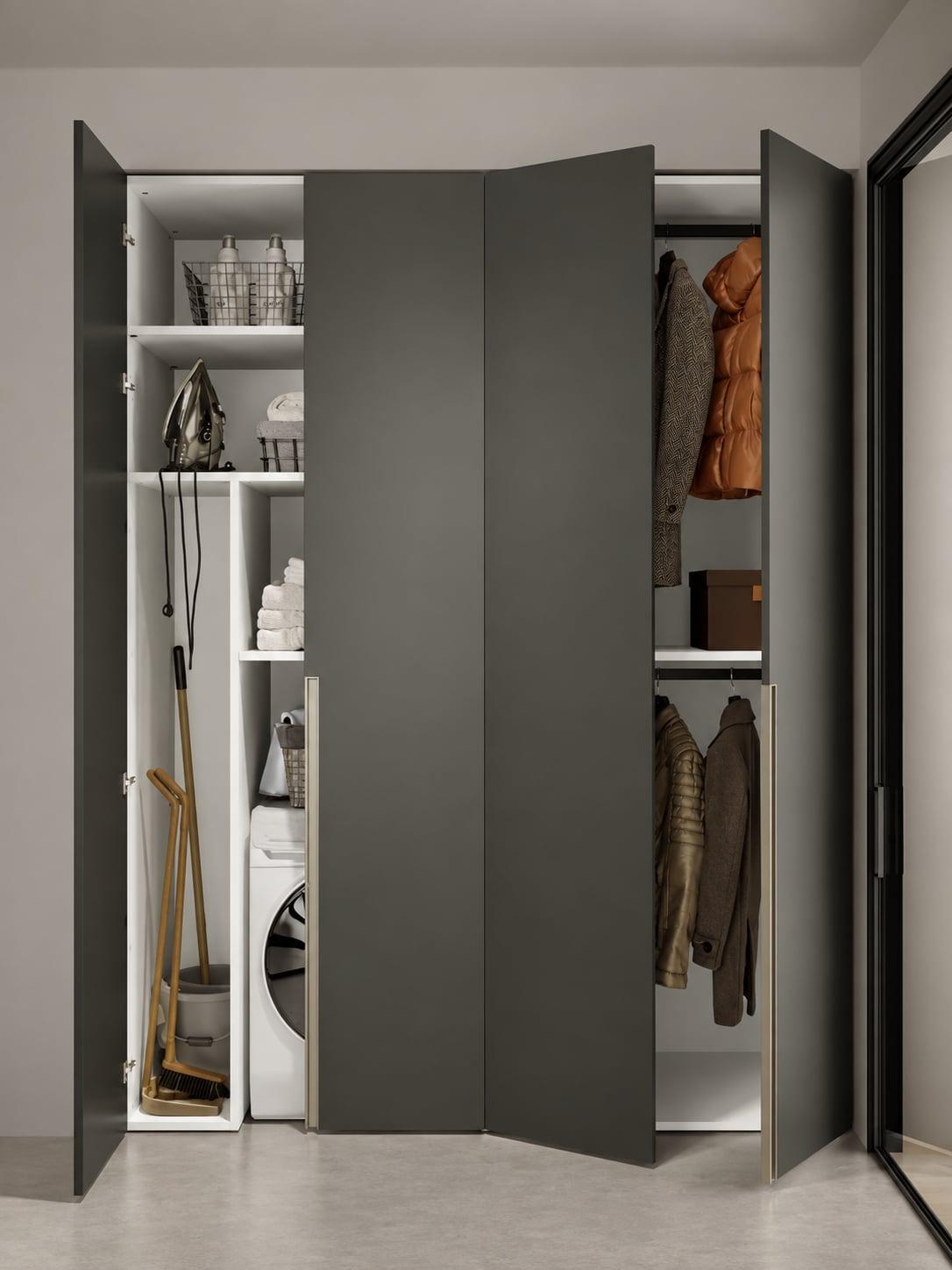Tall laundry cabinet open onto a washing machine, brooms and hanging coats