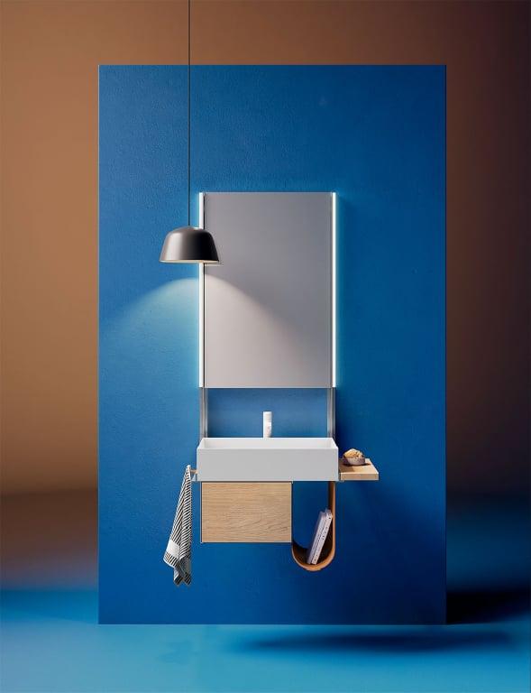 Blue bathroom with a floating vanity, a round basin and a mirror under a black pendant lamp