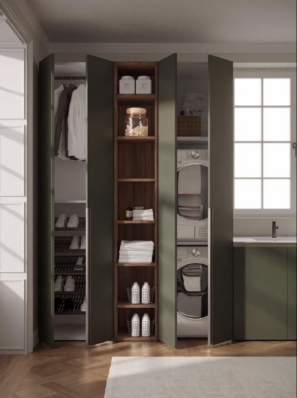 Green cabinetry open onto shelves, a laundry column and hanging space beside a window