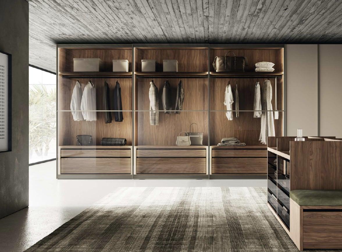 Walk-in closet with glass-fronted wardrobes lit from inside, shirts on the rails