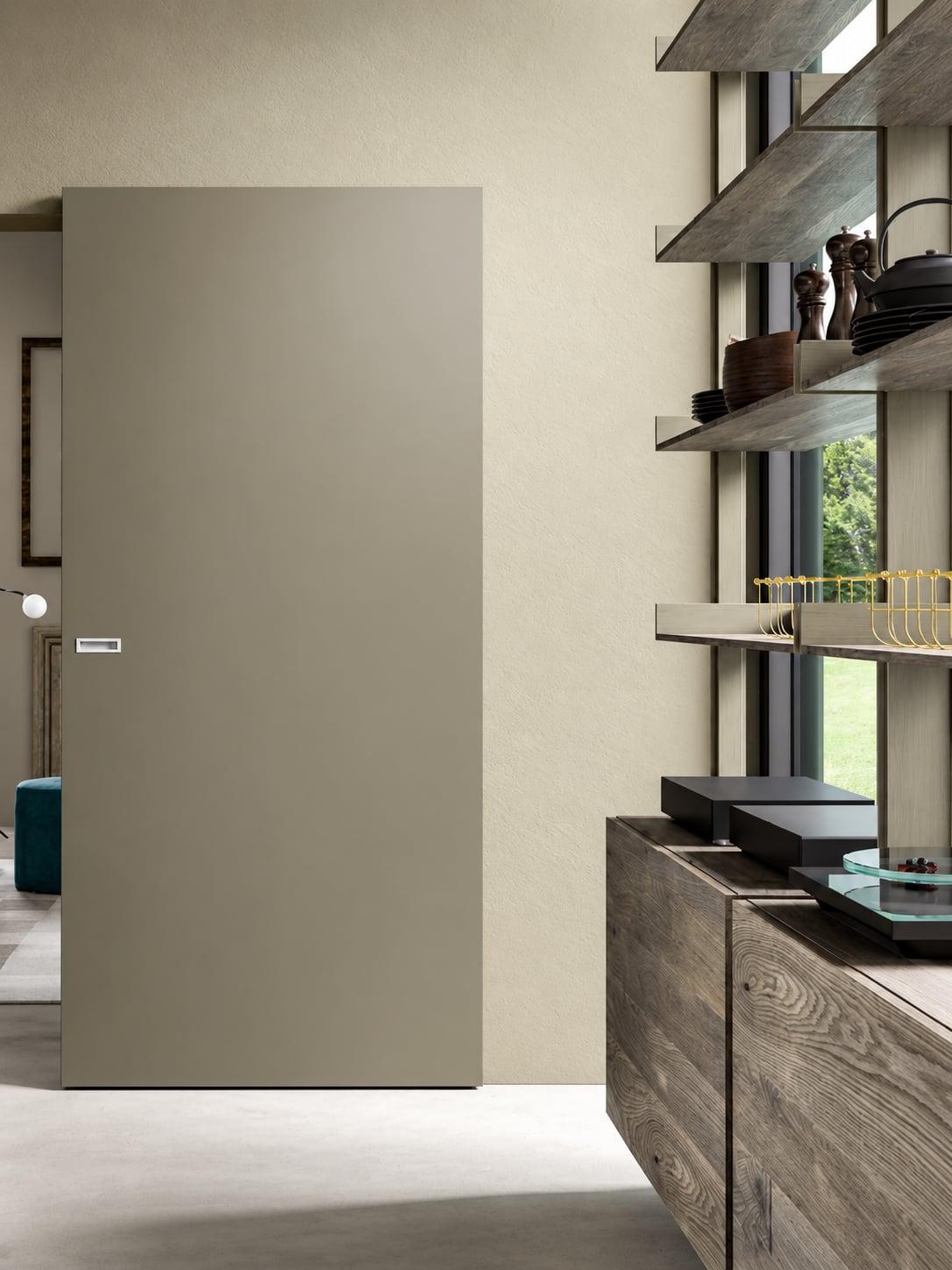 Flush taupe door beside open kitchen shelving