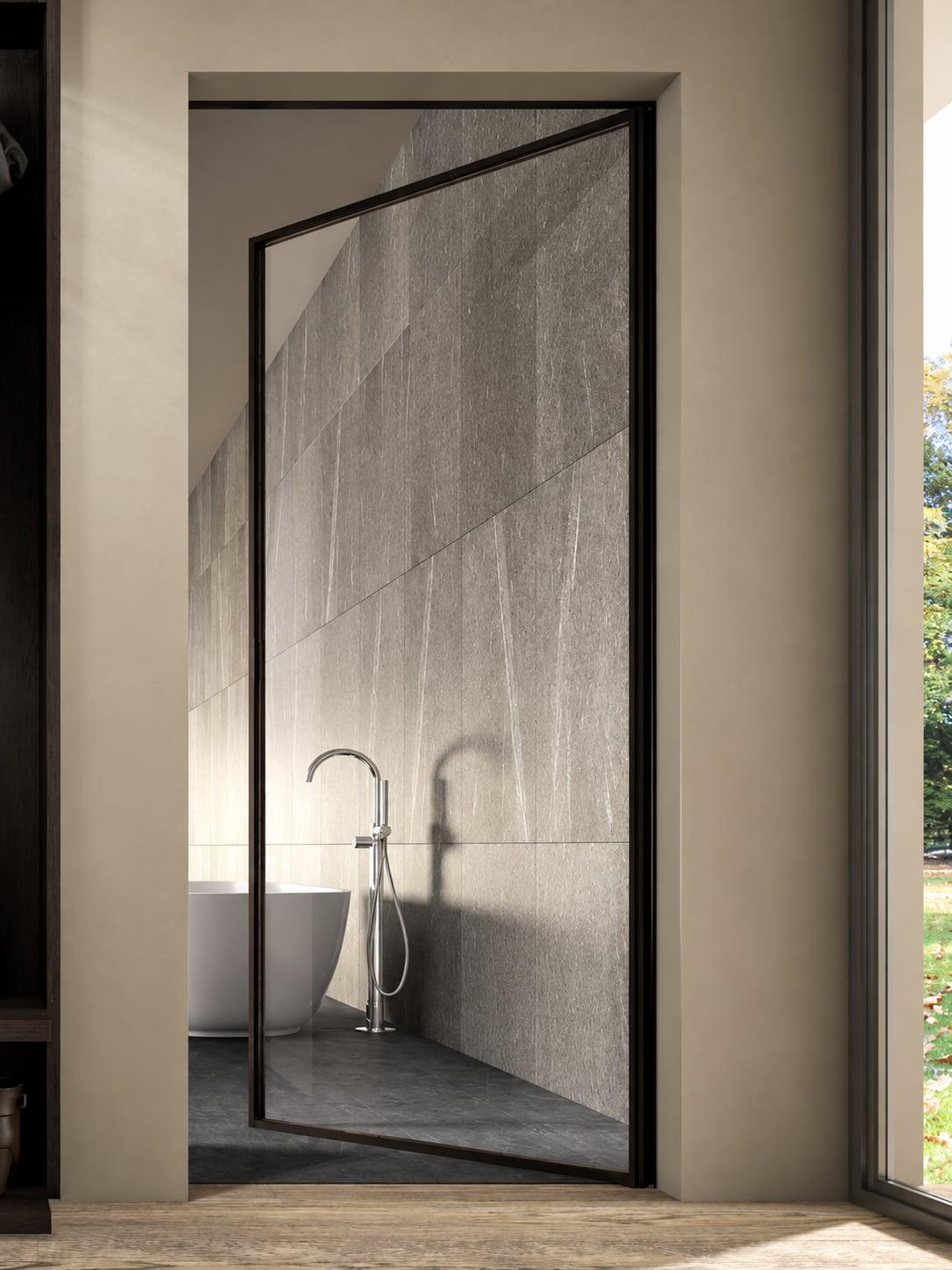 Black-framed glass door opening onto a bathroom