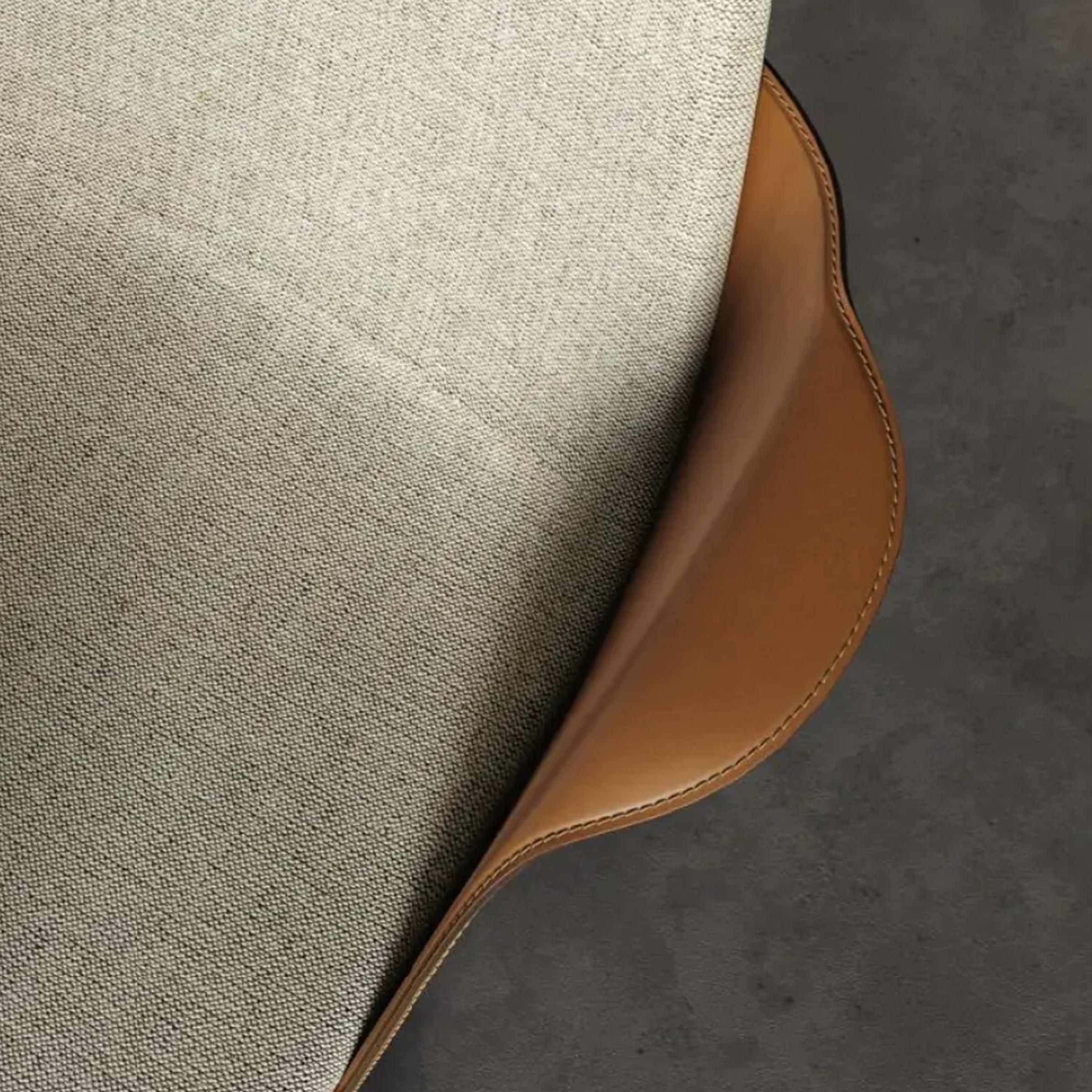 Close-up of a chair seat in woven fabric with a tan leather edge
